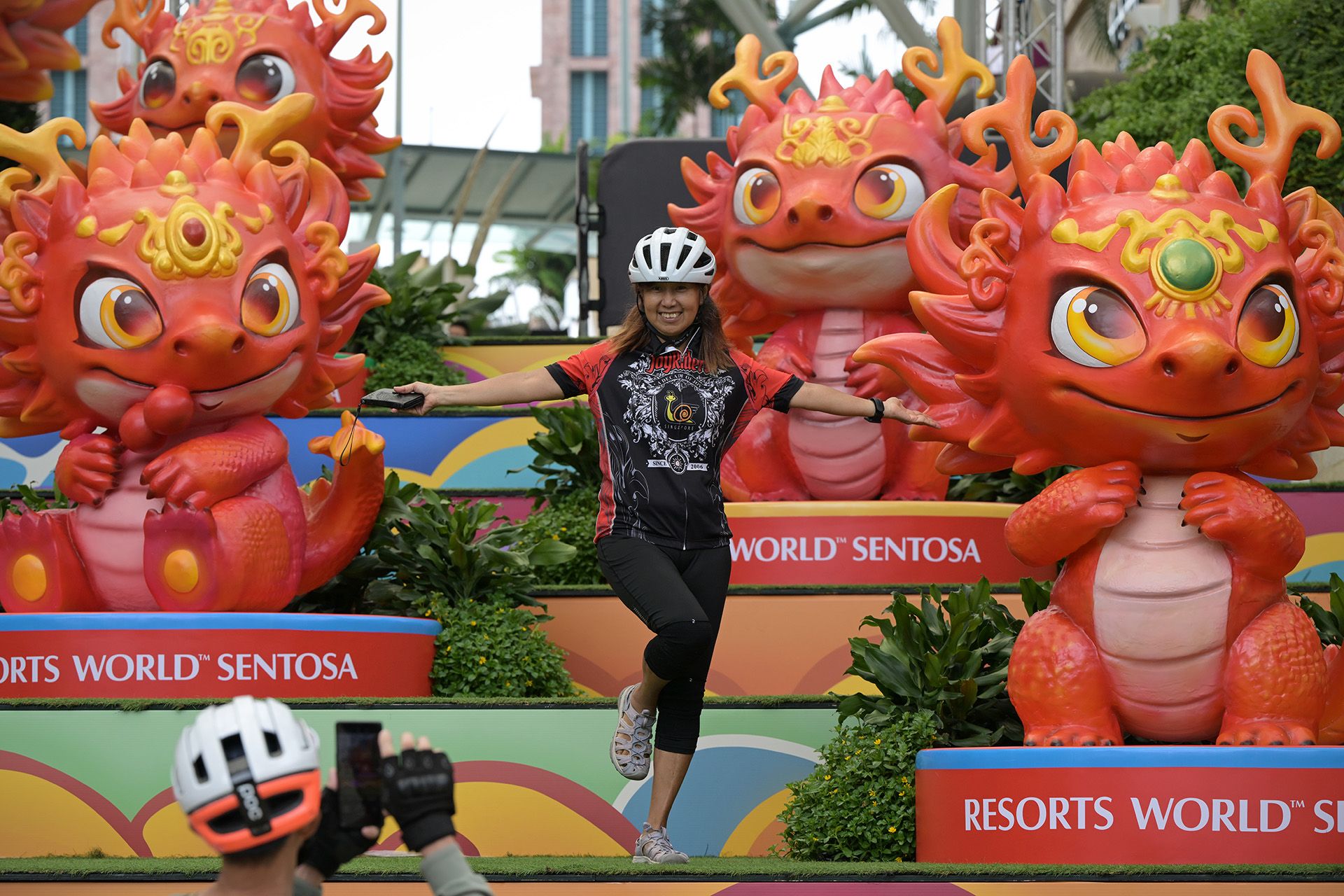A cyclist posing for photos with a group of "mini dragons" at Resorts World Sentosa (RWS), where eight cute dragons are on display with a 5m-tall centrepiece at Ave 8 until Feb 25. ST PHOTO: NG SOR LUAN