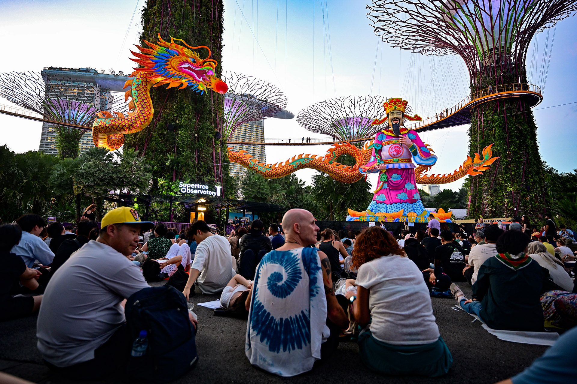 Visitors awaiting the nightly Garden Rhapsody show at Supertree Grove in Gardens by the Bay. A 140m-long dragon lantern is suspended 5m above the ground across two Supertrees, where a 18m God of Fortune also stands tall. ST PHOTO: LIM YAOHUI