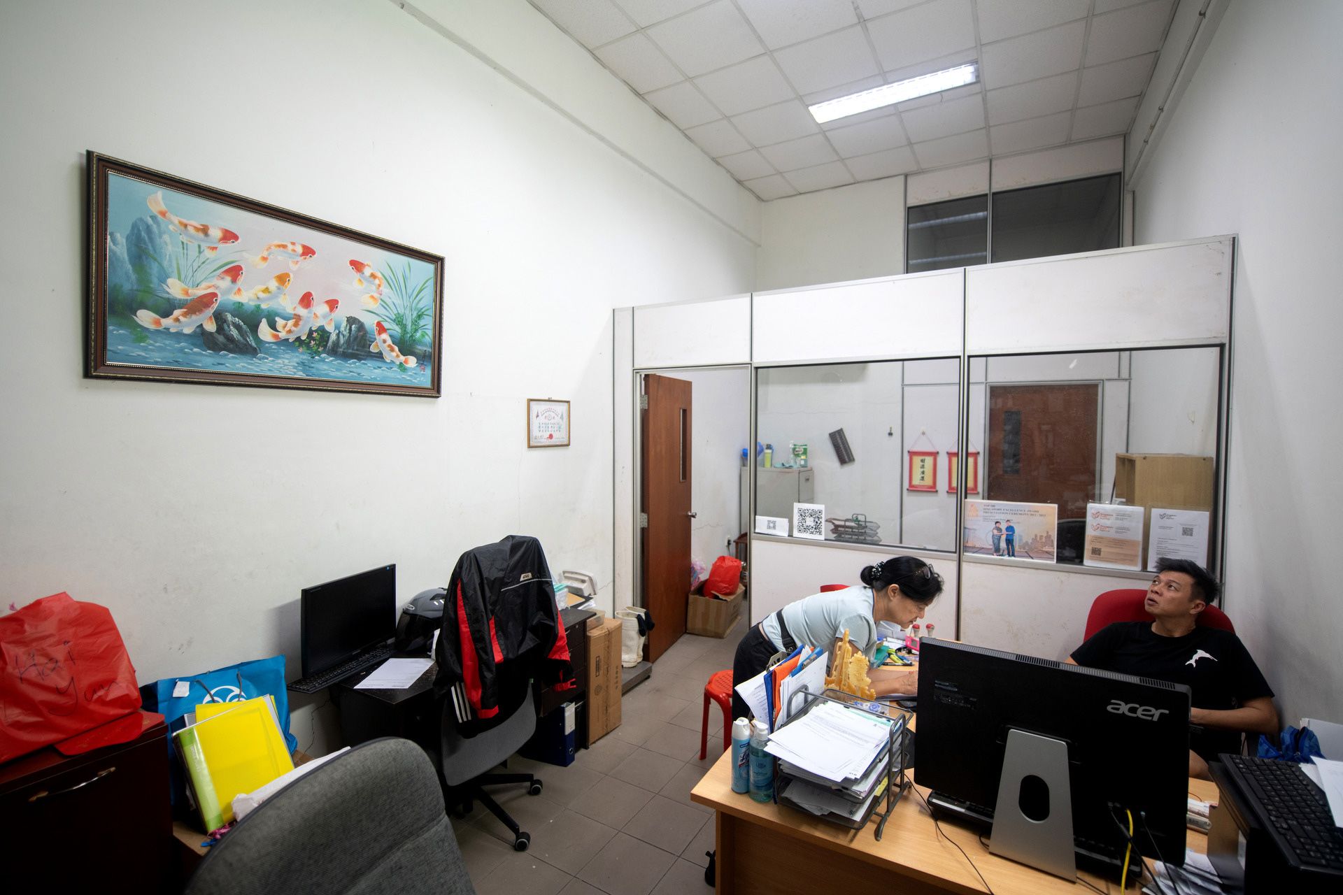 Fish merchant Chris Yap and his accountant Tan Shee Shan discussing the day’s sales figures in the office of Hai Yun Fishery, one of many office units on the second floor of Senoko Fishery Port, after the early morning rush.