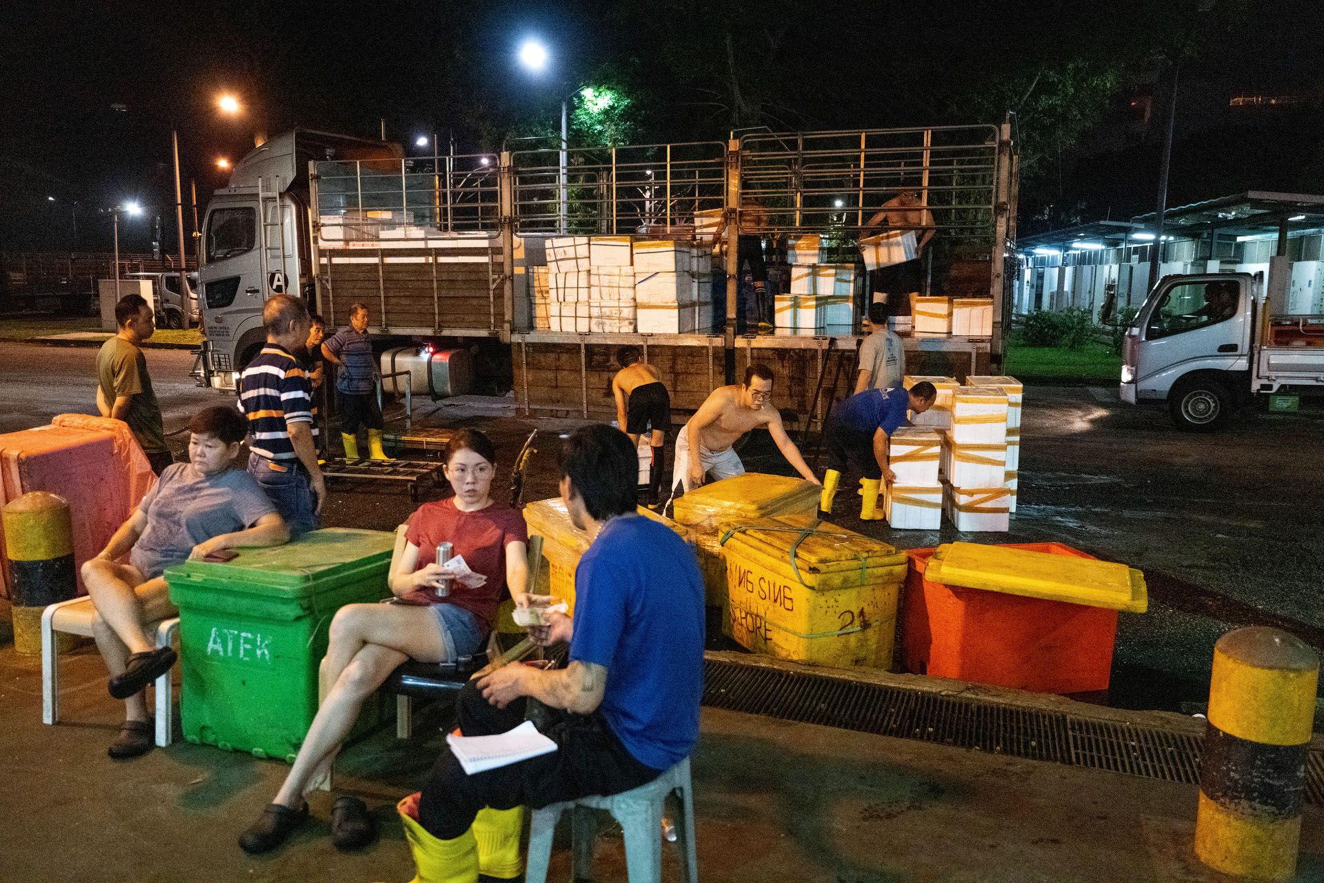 Workers unloading a fresh catch while fish merchants took a coffee break.