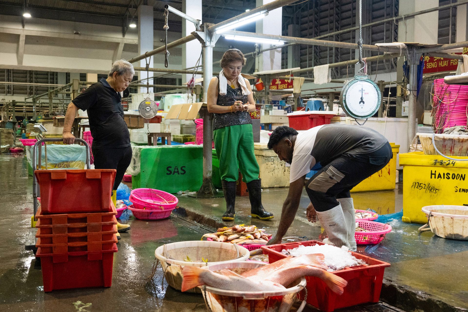Madam Annie Lee watching as her worker prepared fish for sale.