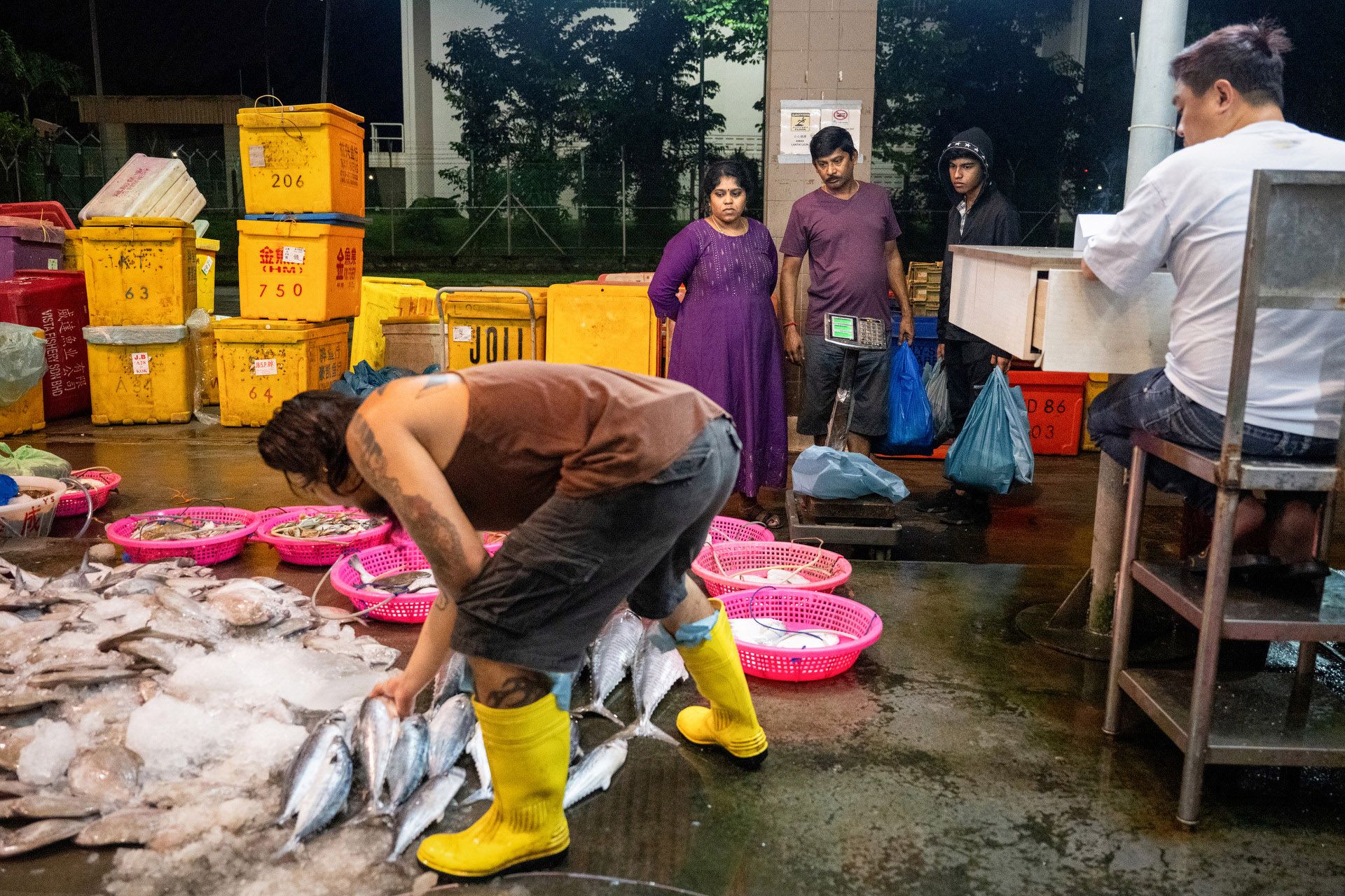 18-year-old student Vin Moorthy (in black) standing next to his parents Suganya and Sathia Moorthy. The family bought sea bass, crabs and prawns to cook curry.