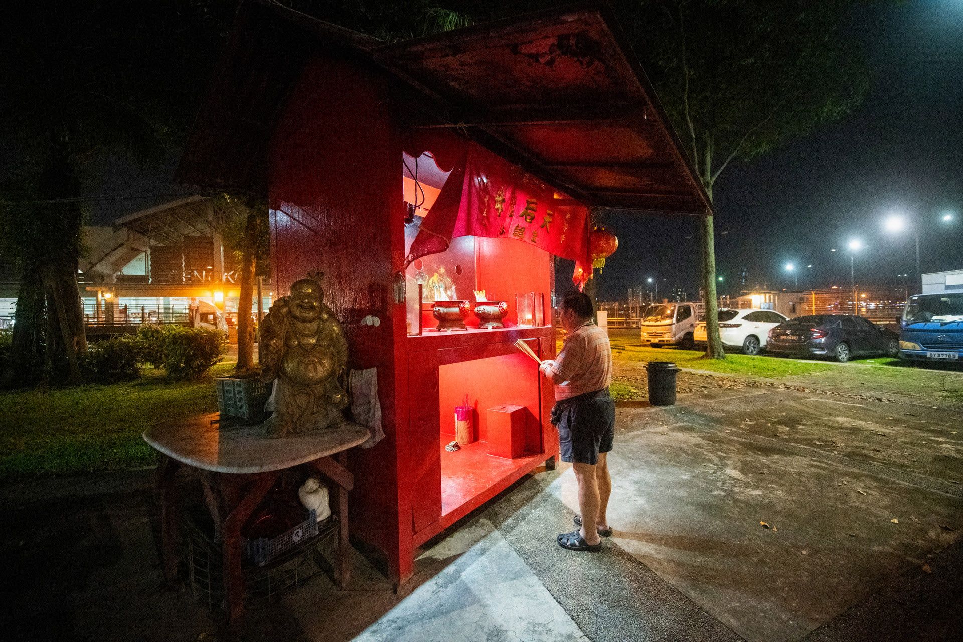 Fish merchant Phillip Yap, 72, offering joss sticks at the altar of sea goddess Mazu, where fishermen used to pray for safety in the seas and a good catch.