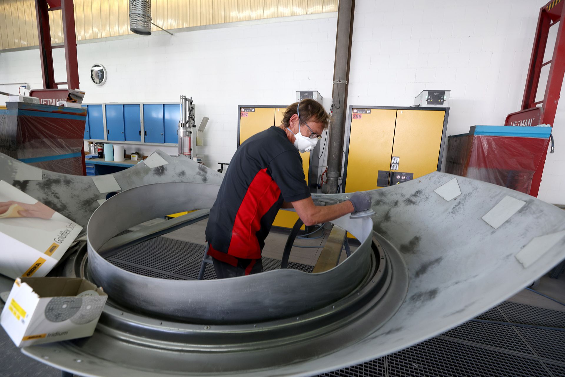 Painting specialist Riccardo Camenisch polishing a fibreglass component of the cabin's exterior.