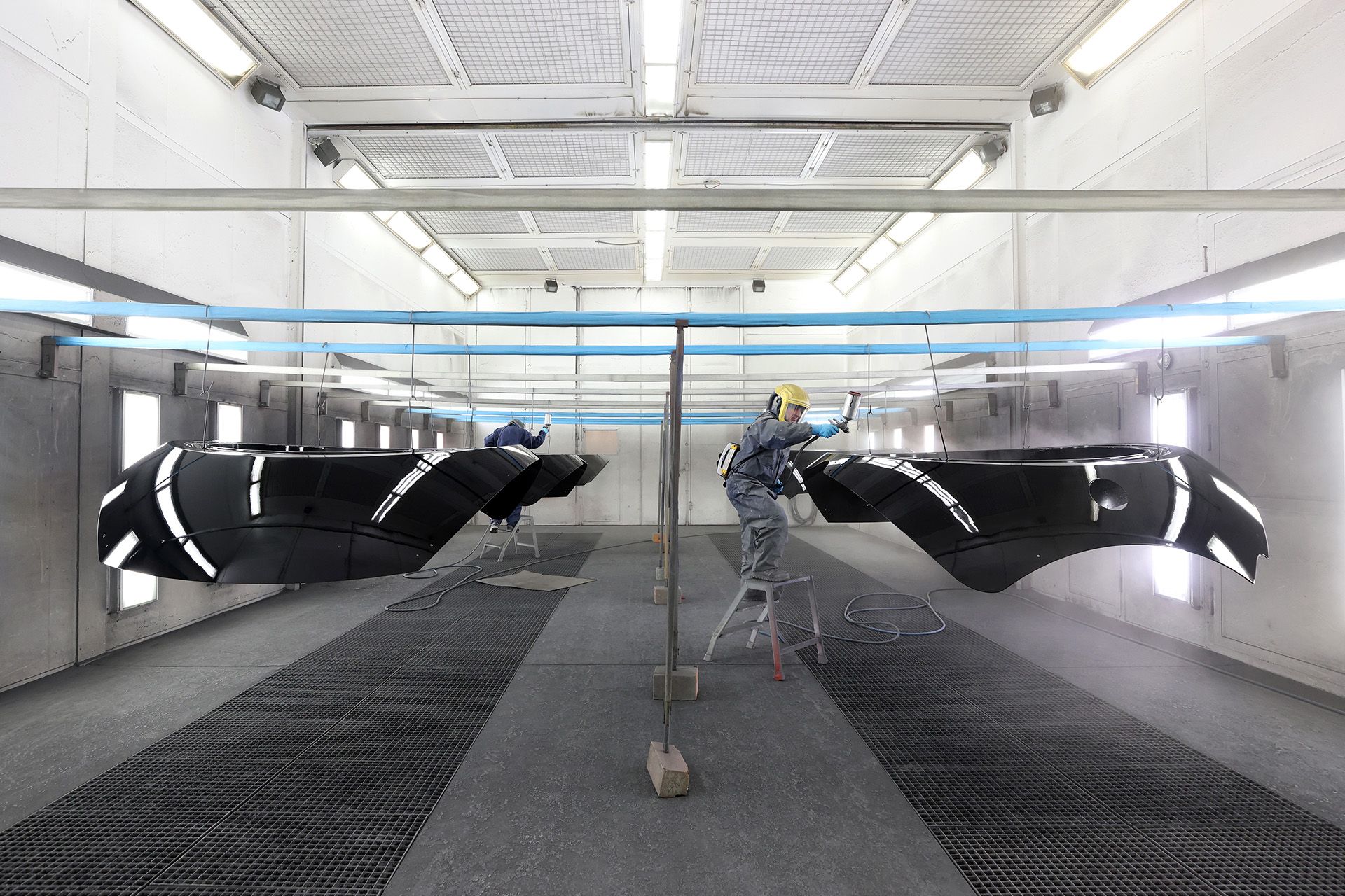 Painting specialist Mahmut Sarioglu painting the cable car cabin exterior using a spray gun. An undercoat of black paint makes the mirrored effect from the subsequent layer of chrome paint possible. A final clear coat is added for protection.