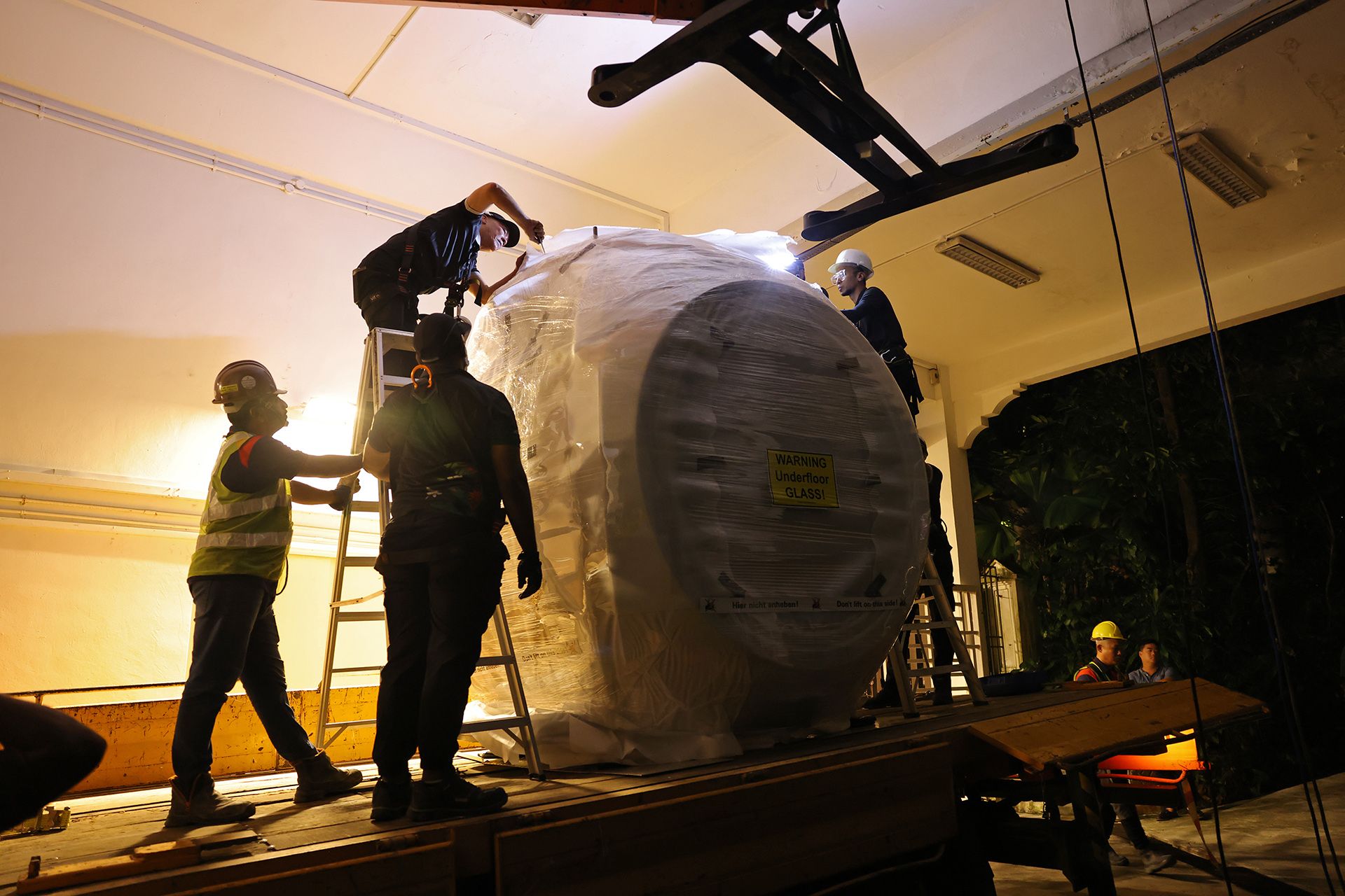 Mr Woo Cheong Yuen (on ladder), a technical operations senior manager with Singapore Cable Car operator Mount Faber Leisure Group, preparing a new SkyOrb cabin to be hoisted from the basement of the Sentosa Cable Car Station to the boarding deck at level 1 on Feb 16.