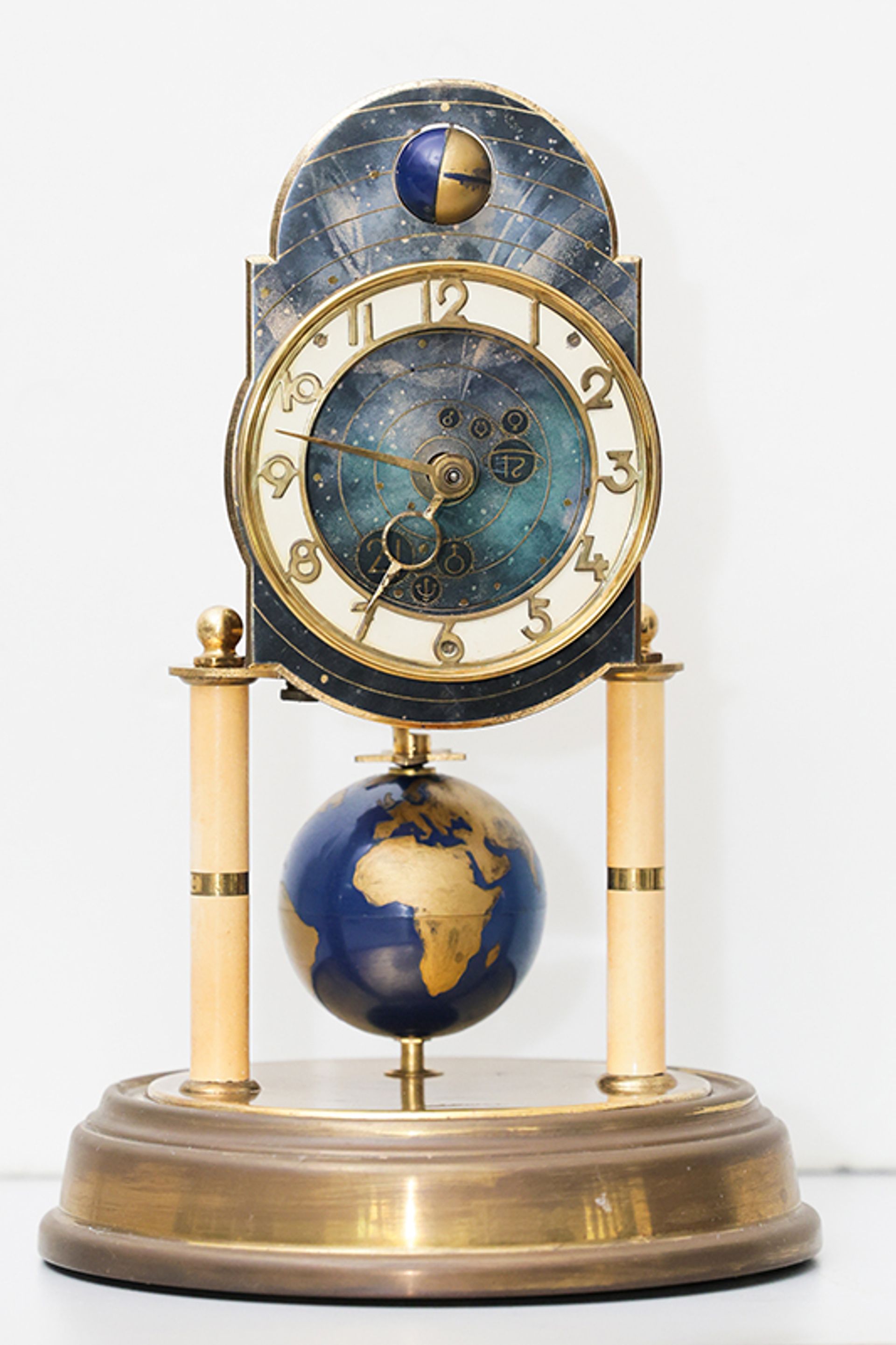 A 400-day clock made in 1954 by J Kaiser that incorporates a moon at the top to show the phase of the moon when the clock runs. It has a rare globe pendulum with regulating weights inside.