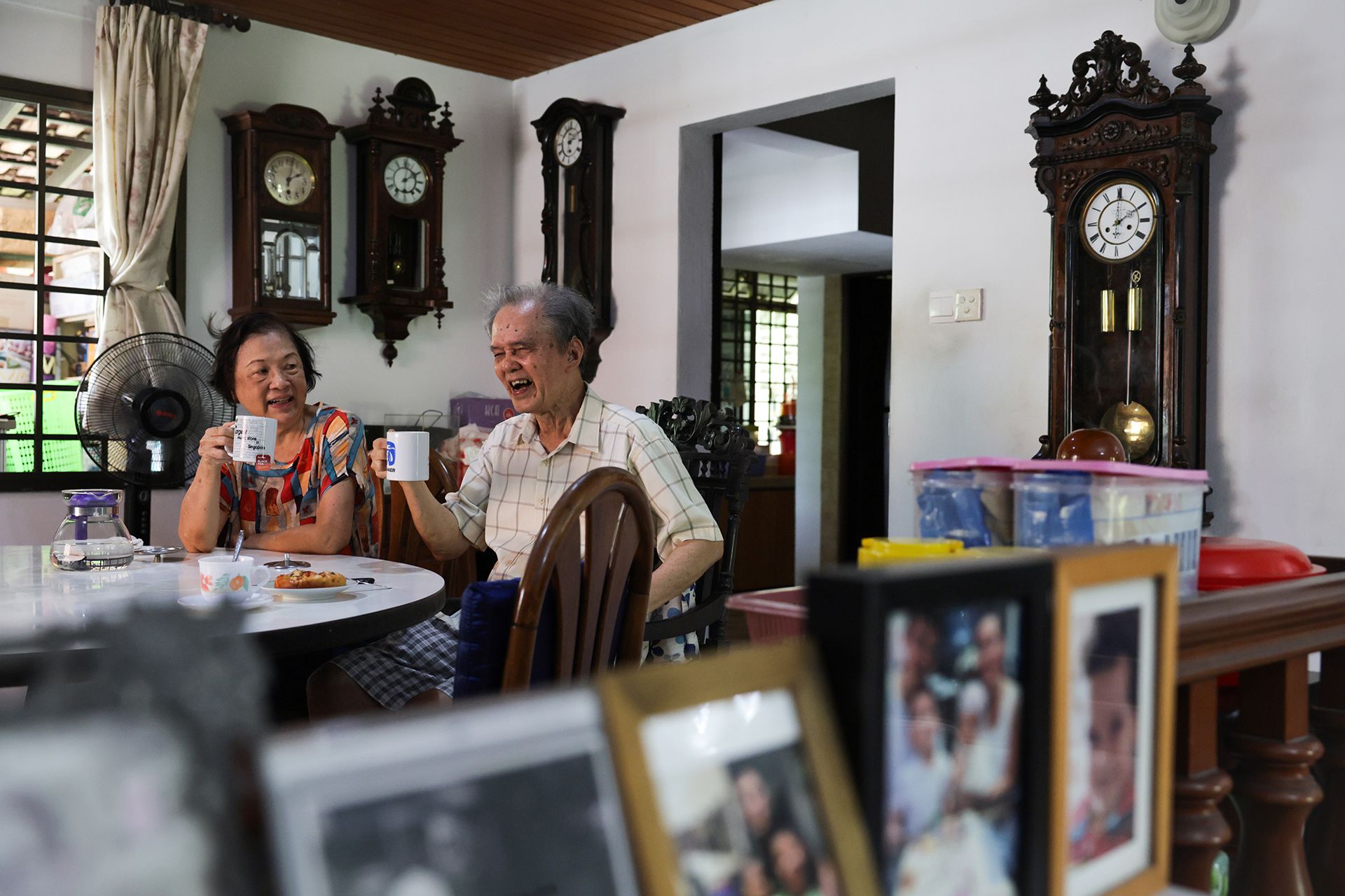 Mr Mun and his wife Tan Ling Cheng sharing a light-hearted moment during tea break in the dining room that is decorated with antique clocks, on April 7, 2024.