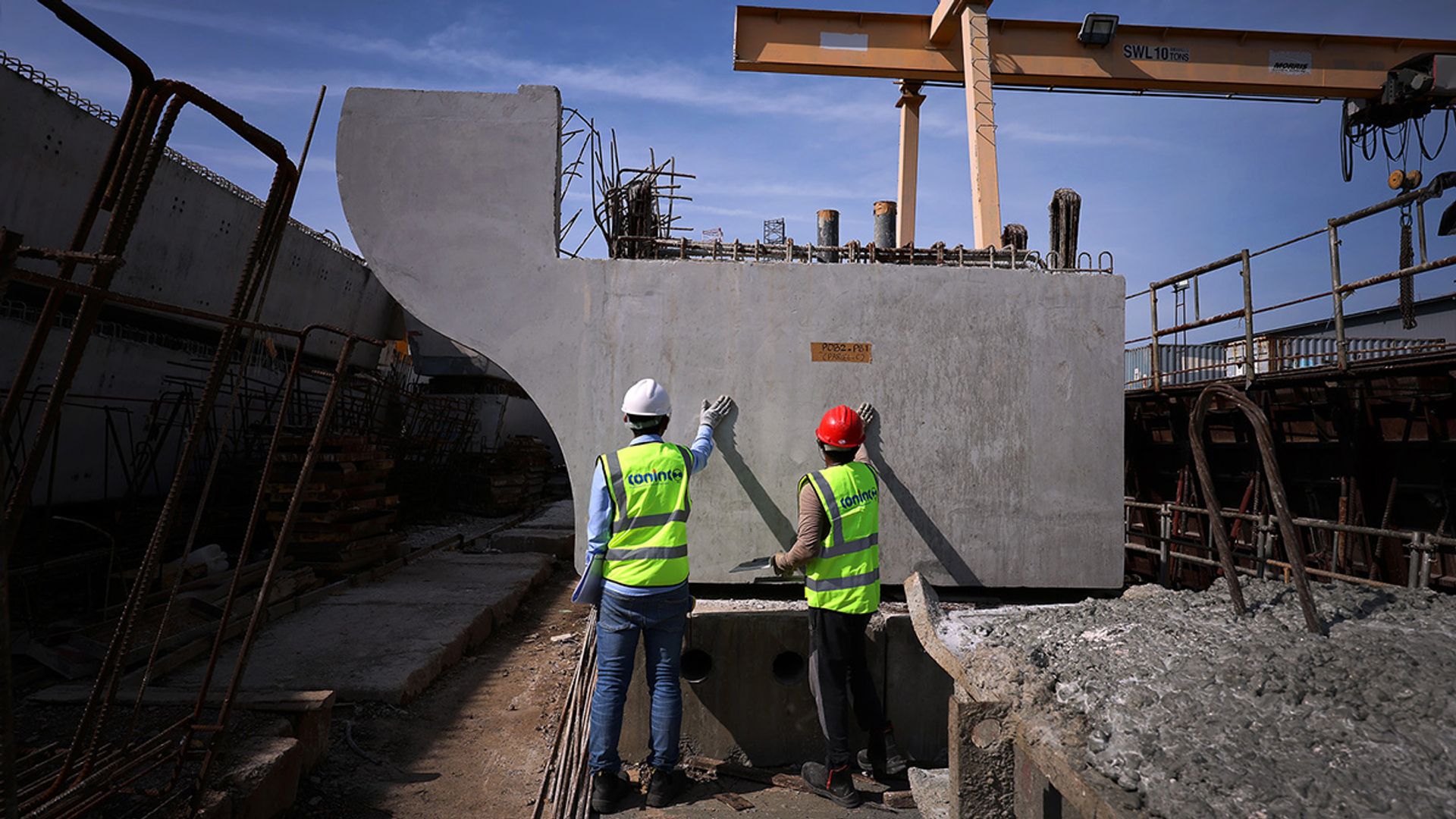 Workers at the Coninco precast yard in Pioneer Sector 2 conducting quality checks on Feb 6 on a concrete beam that will form part of the bridge.