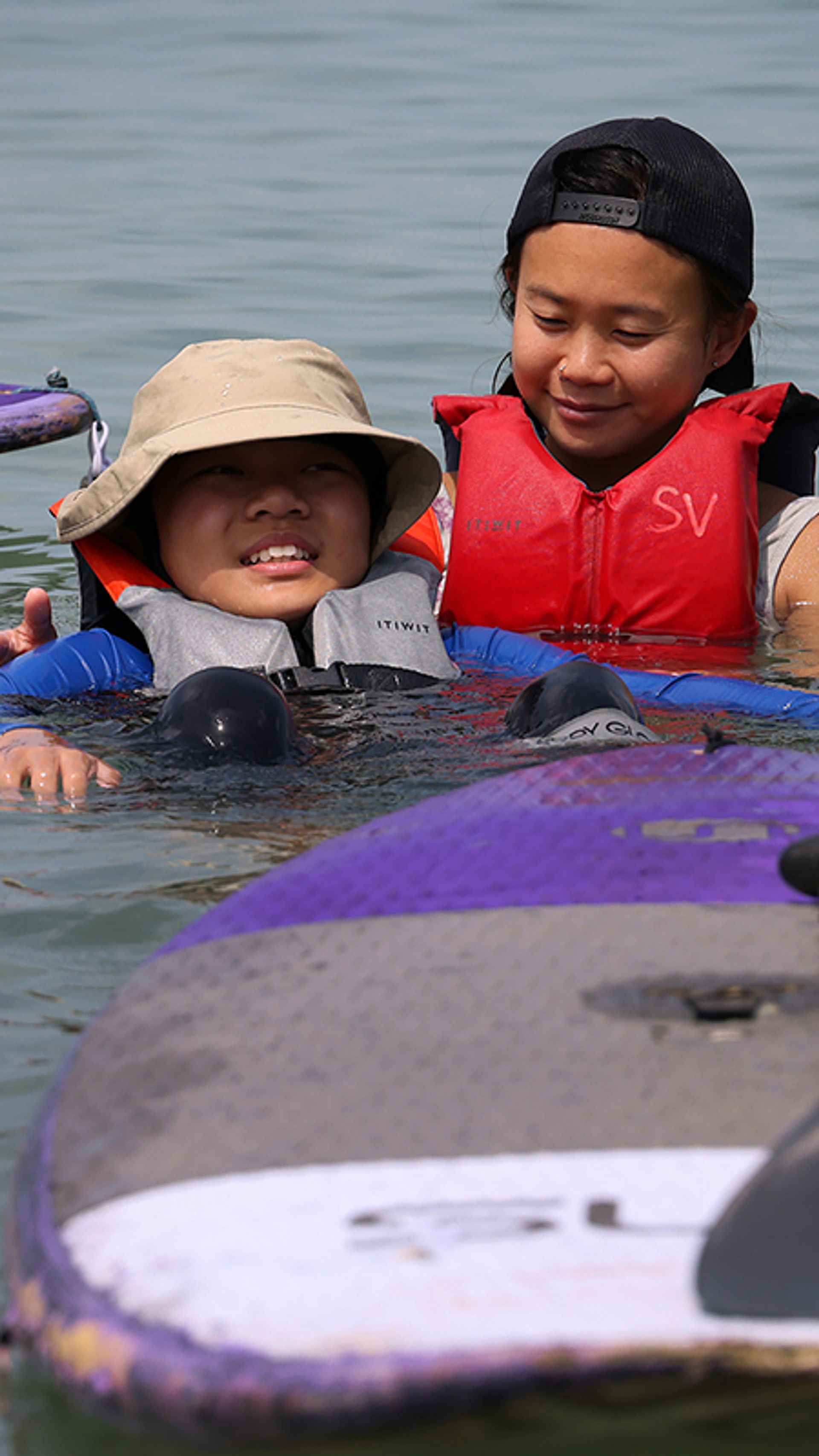 Jozen Lum, 11, relaxing in the sea alongside water sports coach Gracie Teo, 36, during a stand-up paddleboarding lesson, at Siloso Beach, Sentosa, in March. When it comes to coaching kids with autism, there is a delicate balance between keeping them comfortable and pushing their limits, said Ms Teo.