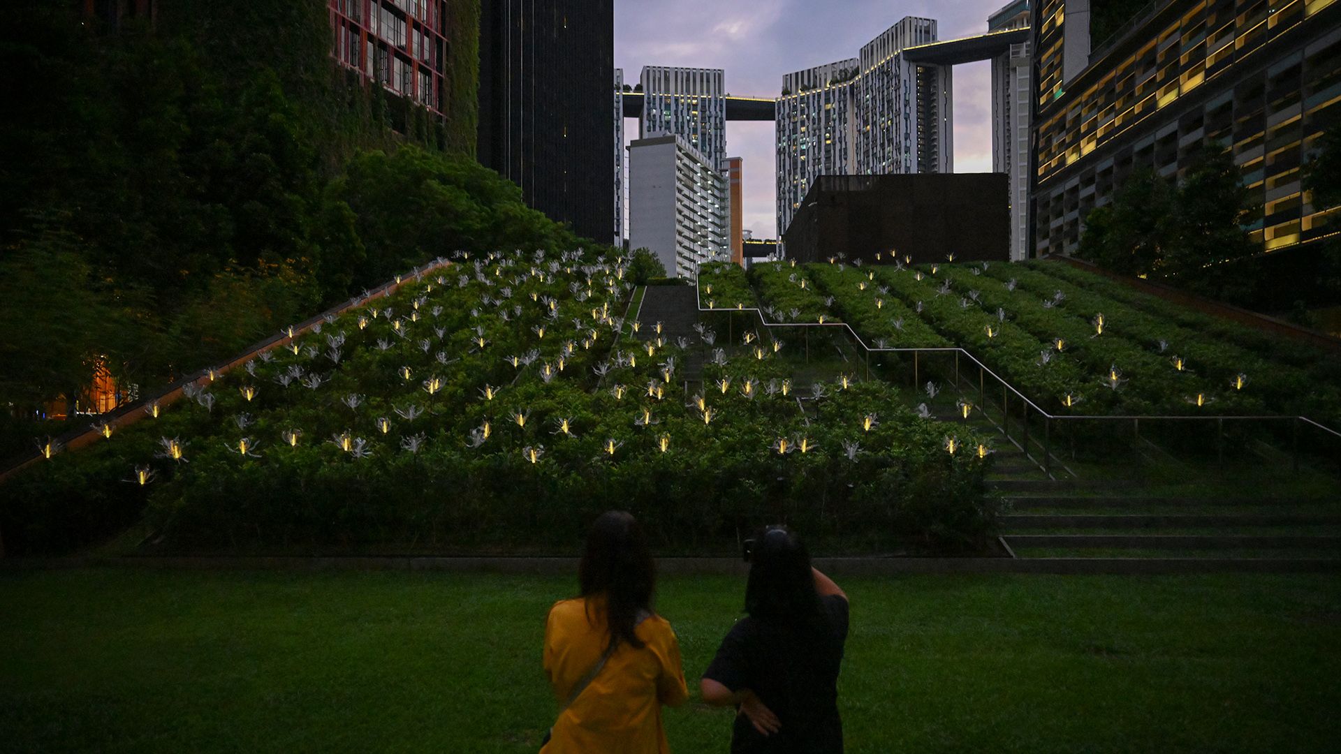 Crew members admiring the installation while looking out for any bottle flowers that did not light up properly at Guoco Tower, Tanjong Pagar Park, on May 26.