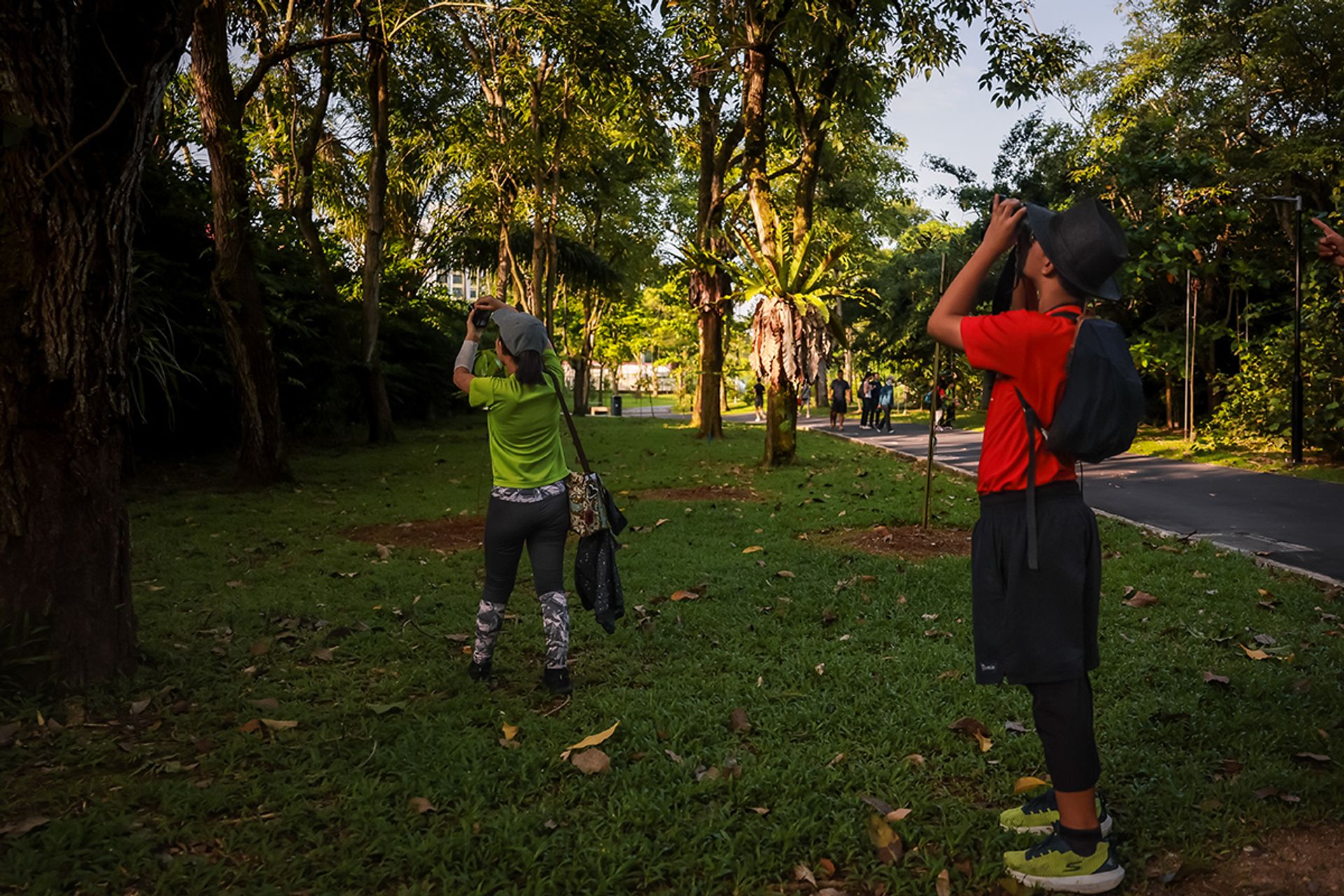 Yumin Primary School pupils Faris Irfan Farid (right), 12, looking for birds with a pair of binoculars as his teammate, Tan En Qi, 12, photographs them in Pasir Ris Park.