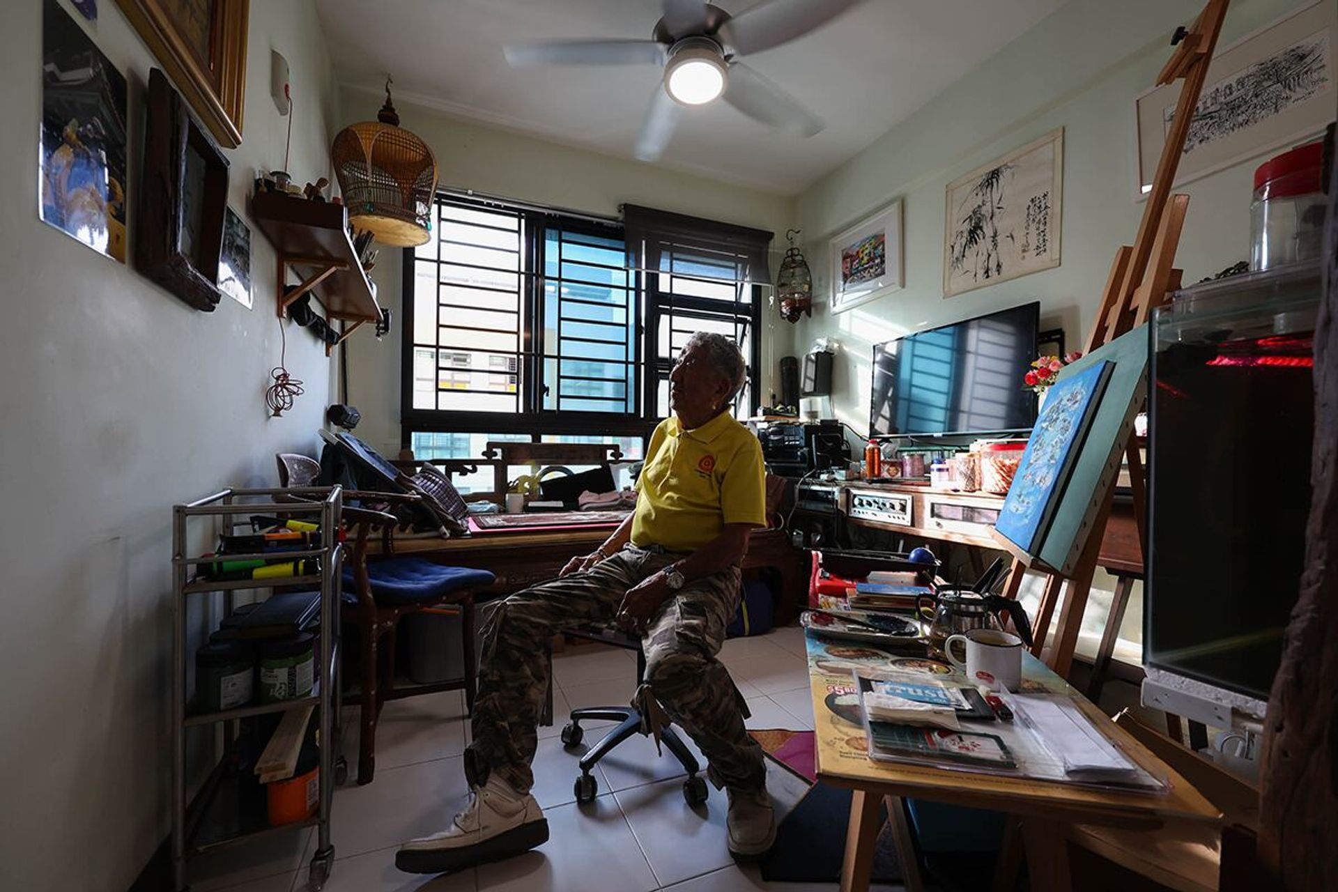 Mr Loke admiring his old paintings in his home at Punggol Emerald on May 30, 2024.