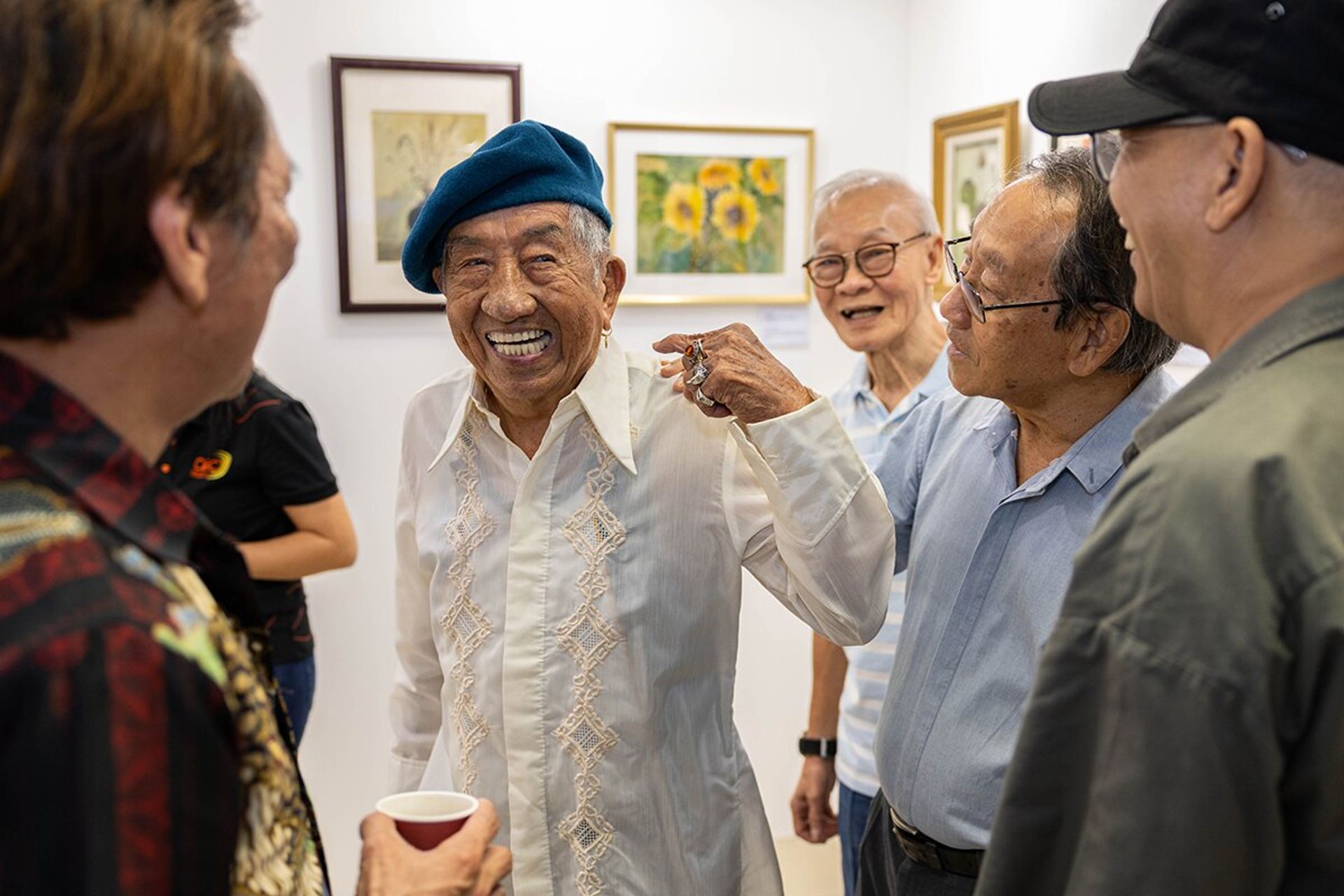 Mr Loke showing off his earring to his artist friends from the Clementi Coffee Shop Group.