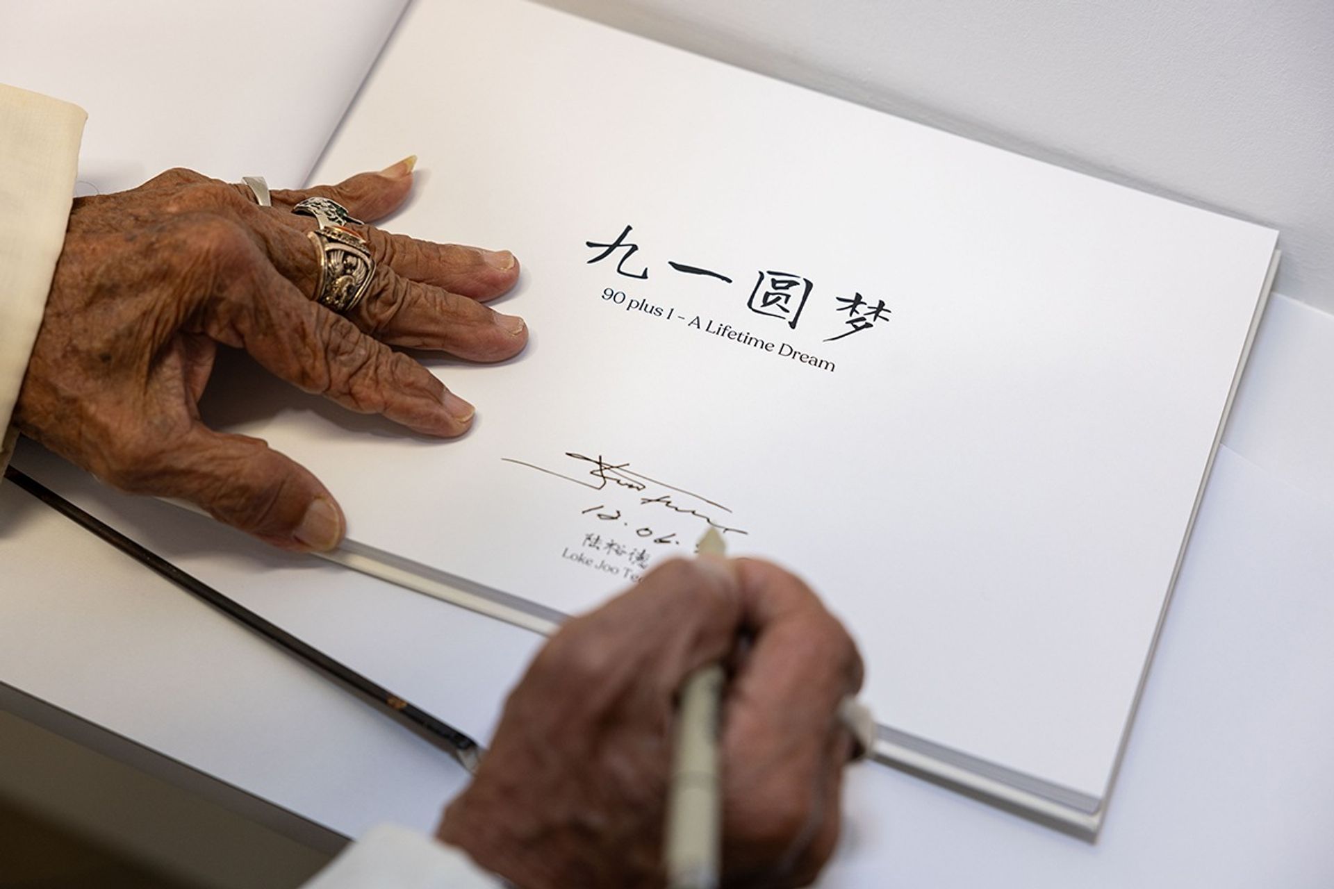 Mr Loke signing his book at the opening of the art exhibition on June 12, 2024.