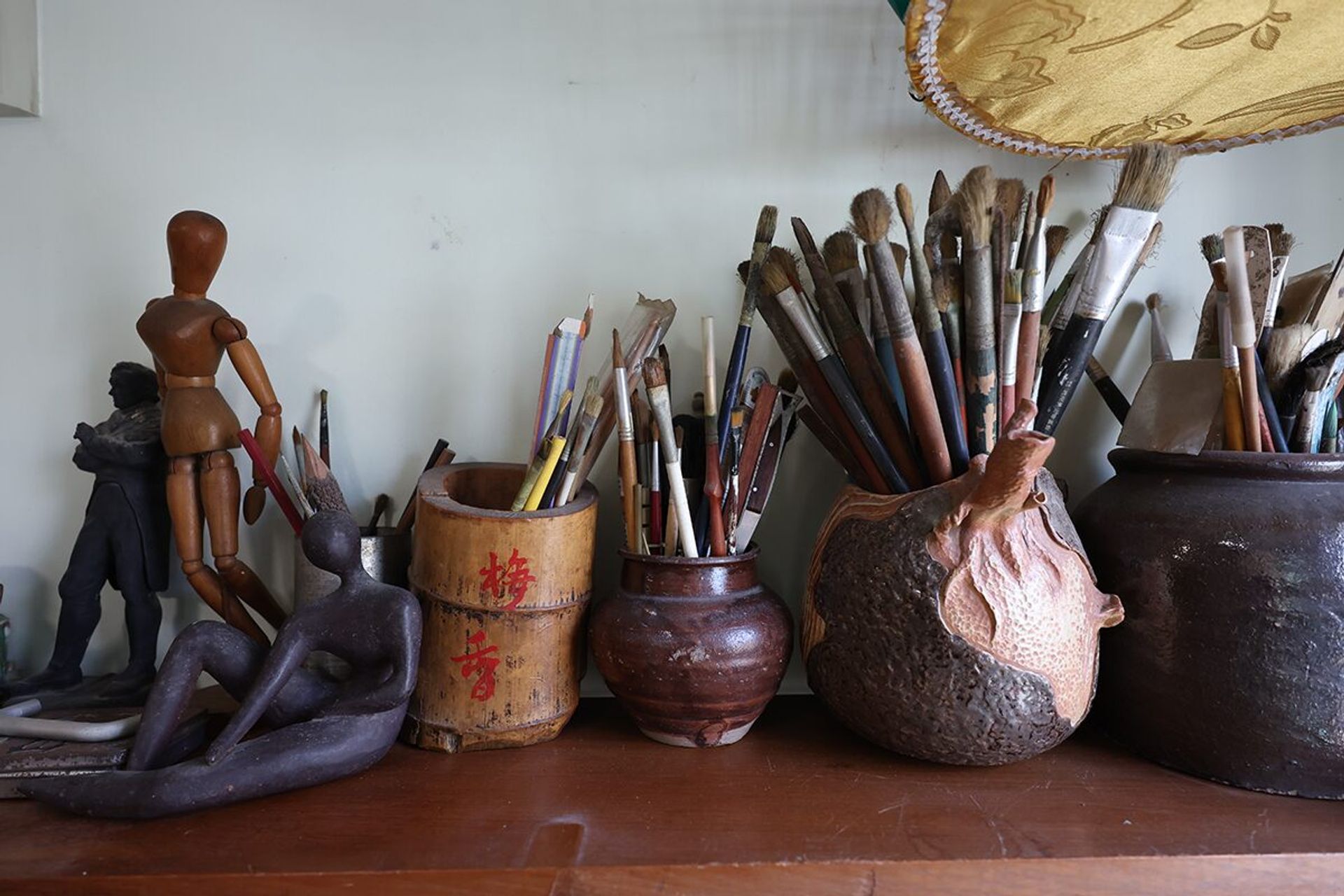 Well-used paintbrushes are among the many art materials, collectibles and books in his home.