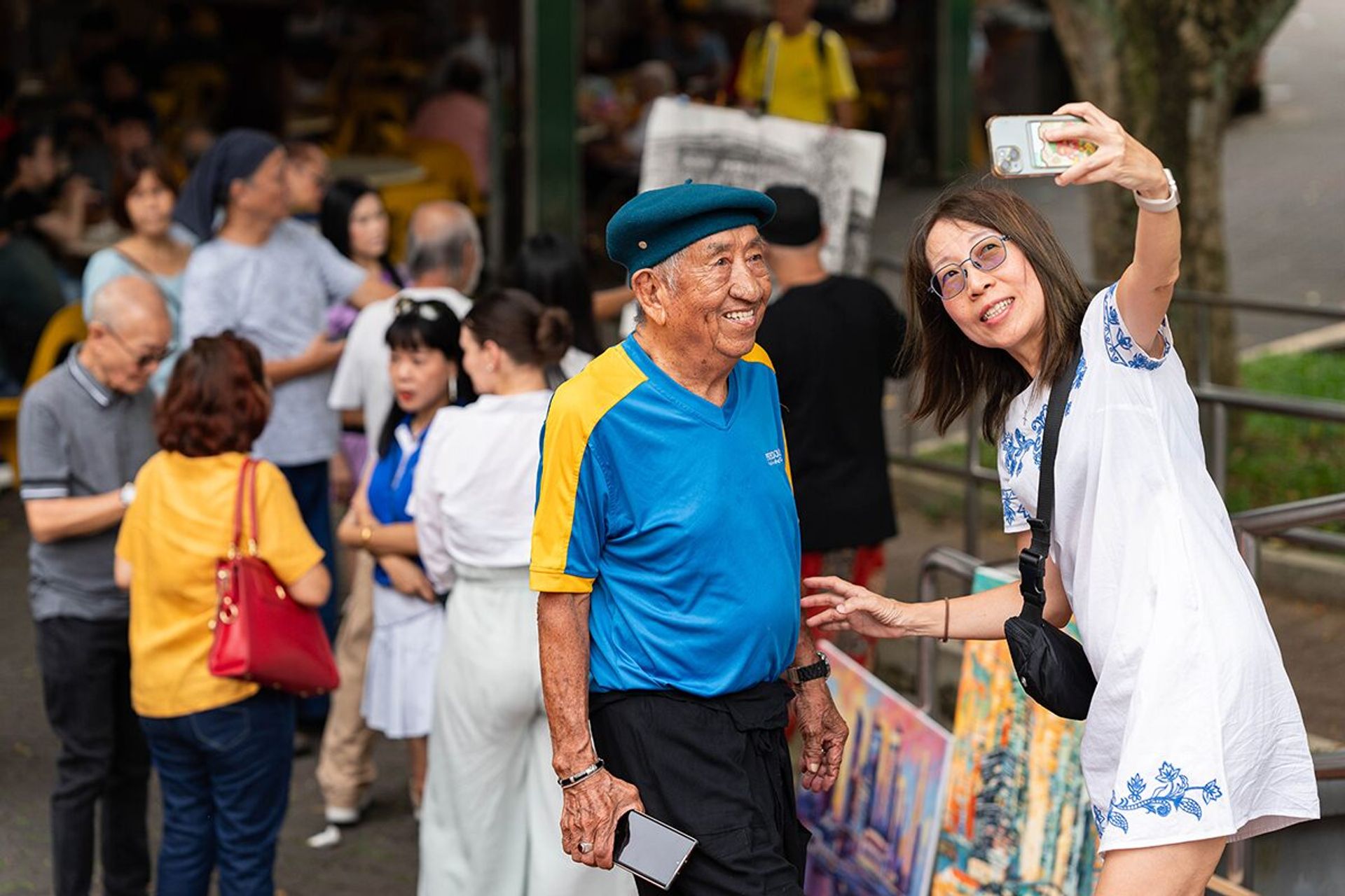 Ms Loke taking a picture with her father at a meeting of the Clementi Coffee Shop Group, at Block 325, Clementi Avenue 2, on June 2, 2024.