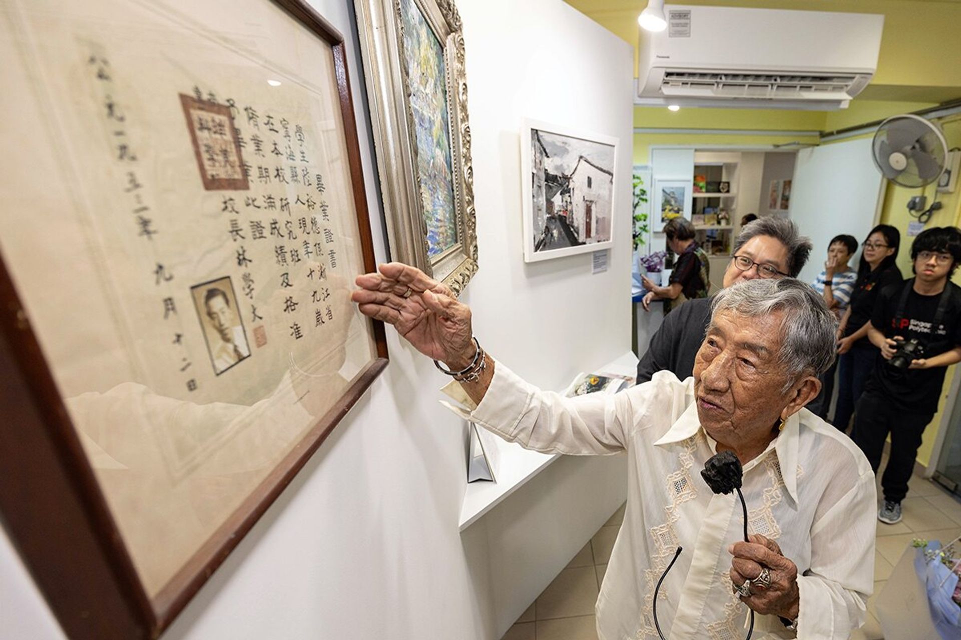 Mr Loke telling visitors about his Nafa graduation certificate at the art exhibition on June 12, 2024.