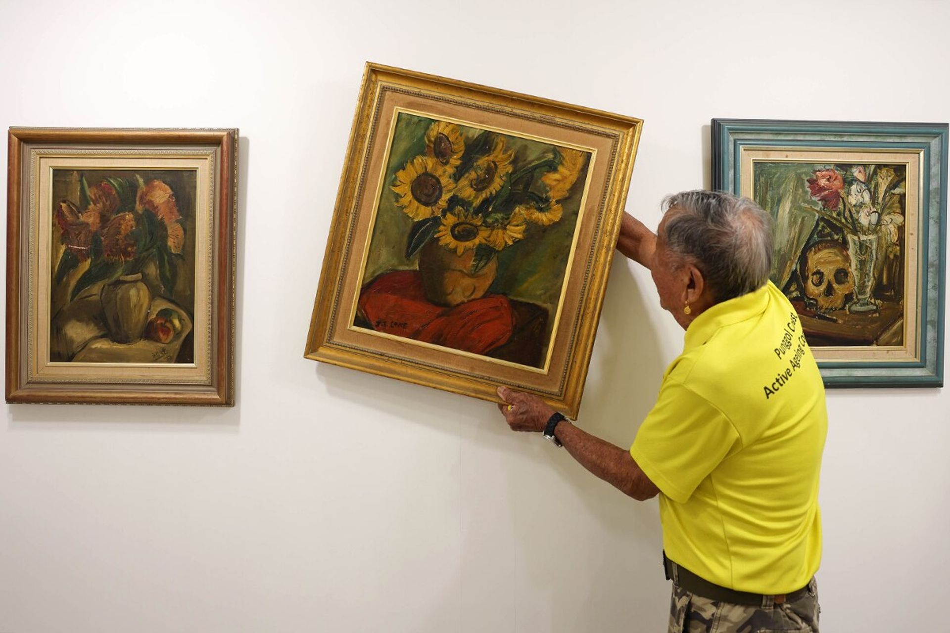 Mr Loke putting up a painting at the active ageing centre, which was transformed into an art gallery.