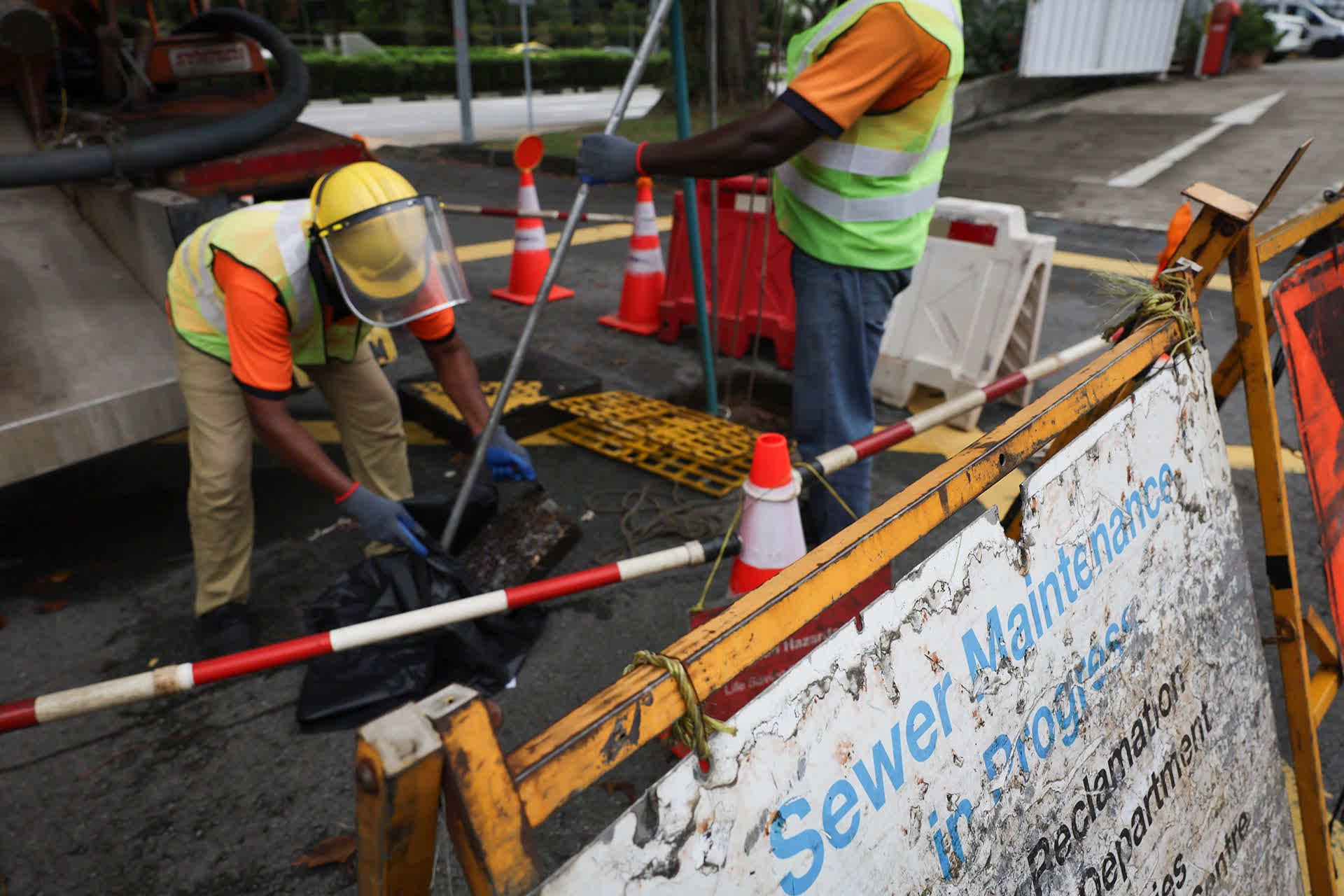 Sewerage maintenance officers capture the debris being washed down using a grit catcher at Monk's Hill Terrace on May 24, 2024.