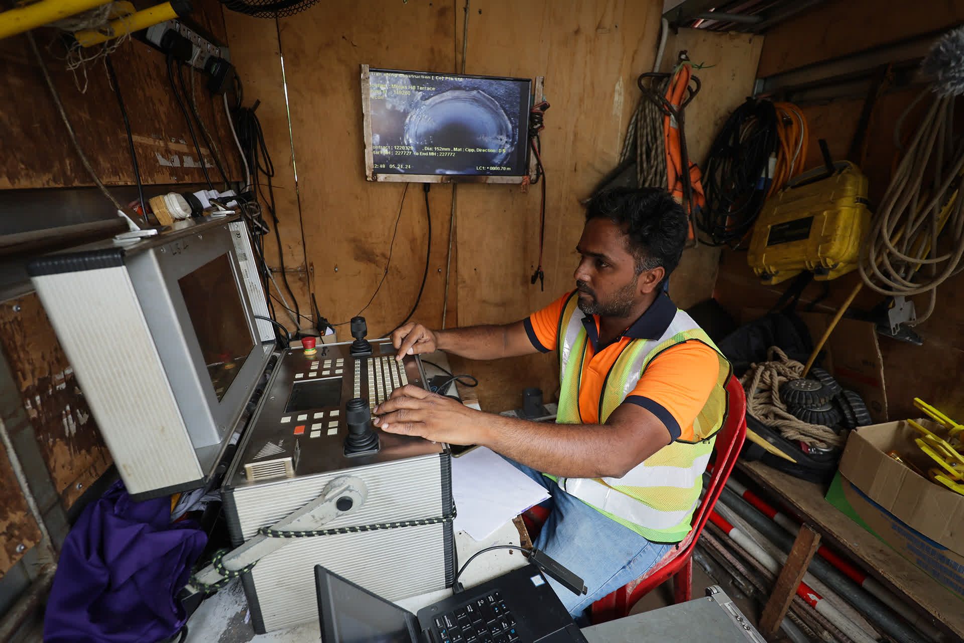A sewerage maintenance officer operating a remote-controlled robotic CCTV camera from a truck at Newton Food Centre, on May 24, 2024.
