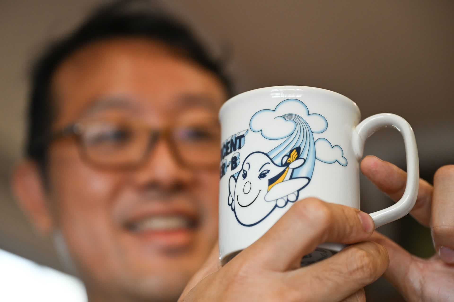 Dr Ong pointing to a crack visible on the handle of a cup that he used from Primary 3 to Primary 6. He stopped using it because of the crack.