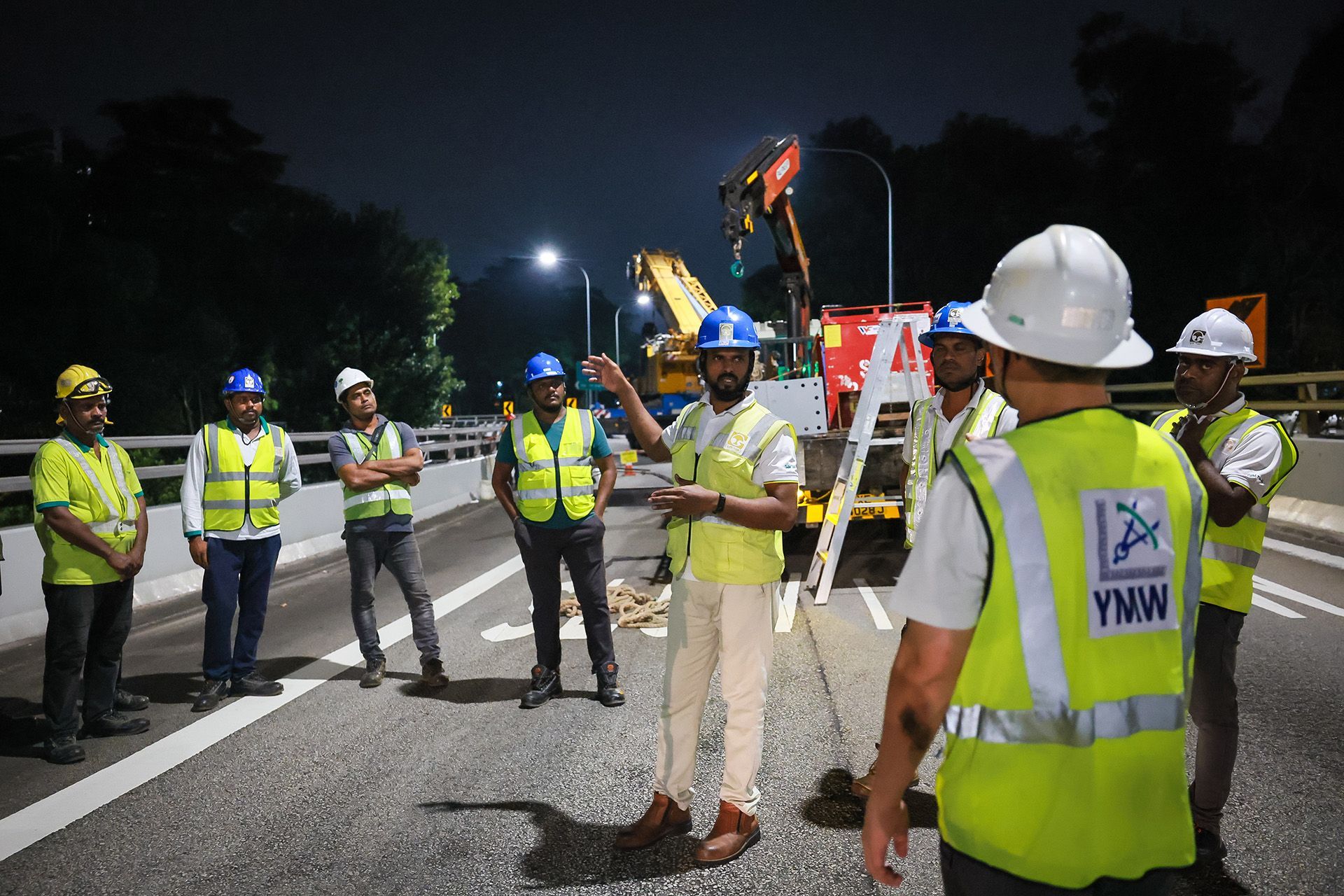 A worker briefs his team on technical procedures and safety considerations.