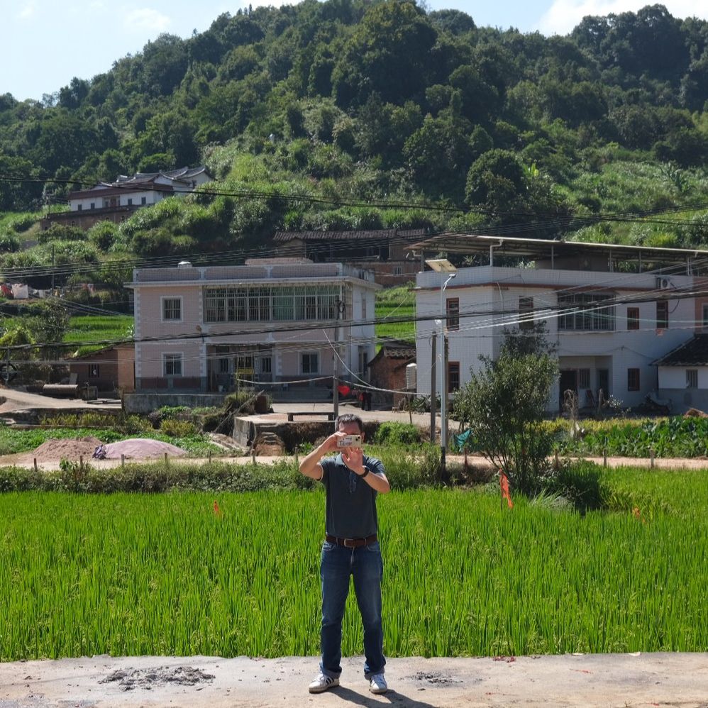 A participant on a *xun gen* tour taking photos of Zhiyang village in Anxi, which has become more developed over the past few years.