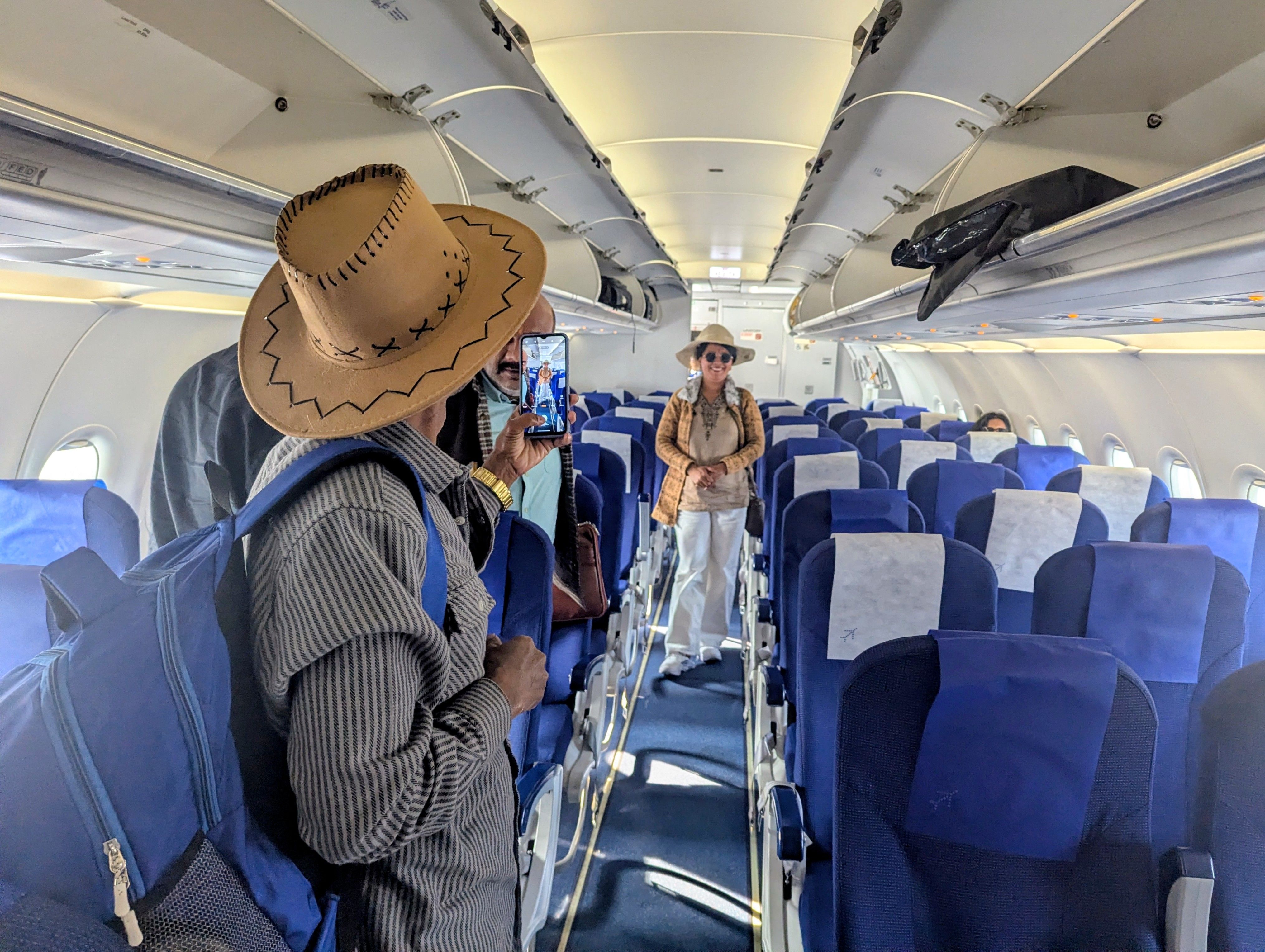 Mrs Sakku Kumari, wearing a cowboy hat and sunglasses, poses for a photo inside the hull of an airplane.