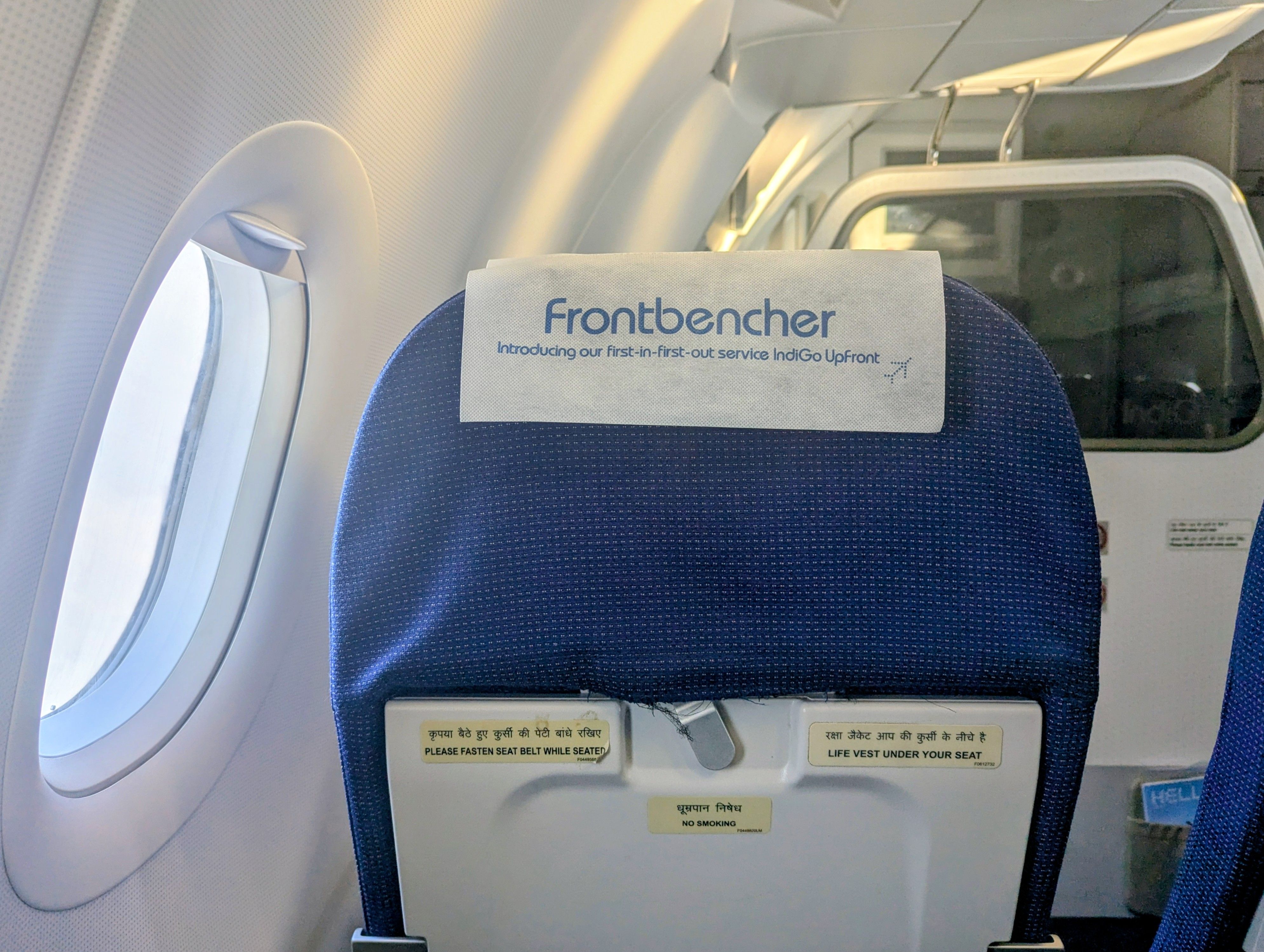 The back of a seat in an IndiGo plane says: “Frontbencher. Introducing our first-in-first-out service IndiGo Upfront”.