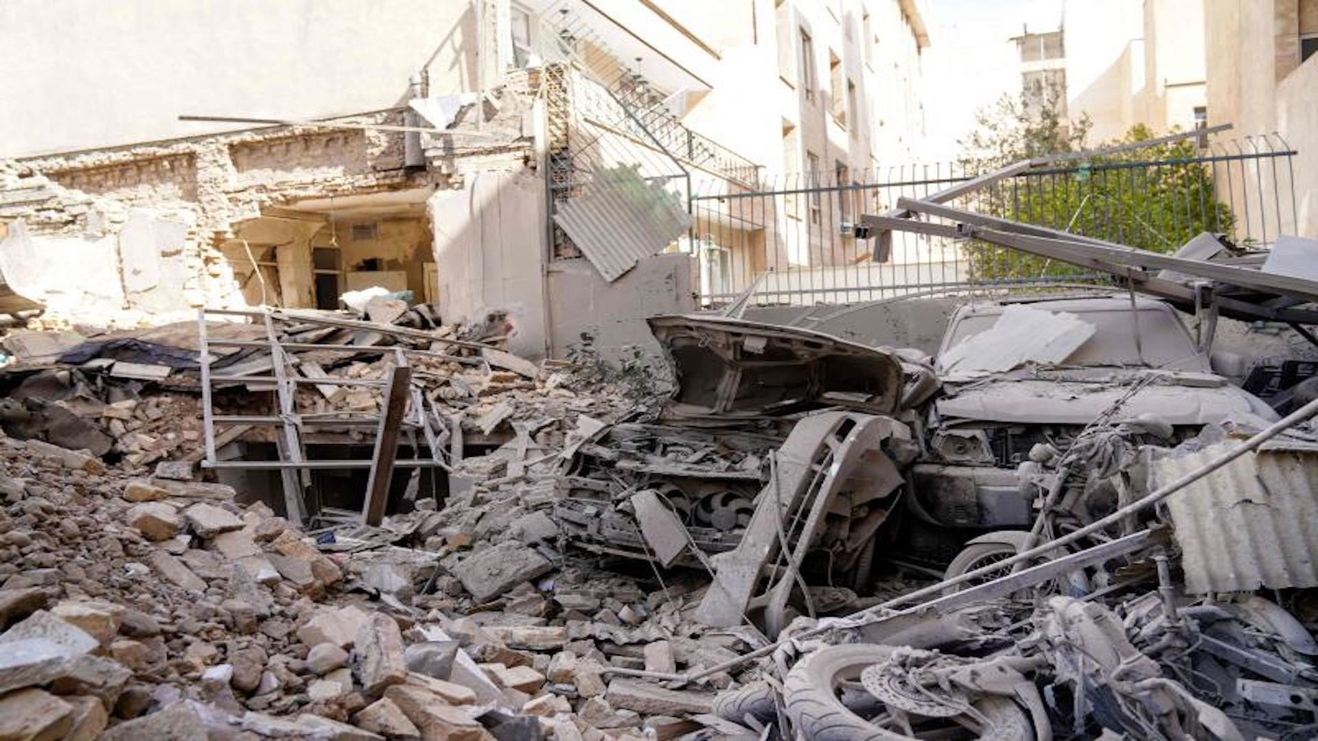 Rubble and debris surround a destroyed vehicle in a residential neighbourhood of Tehran following missile strikes on February 28, 2026.