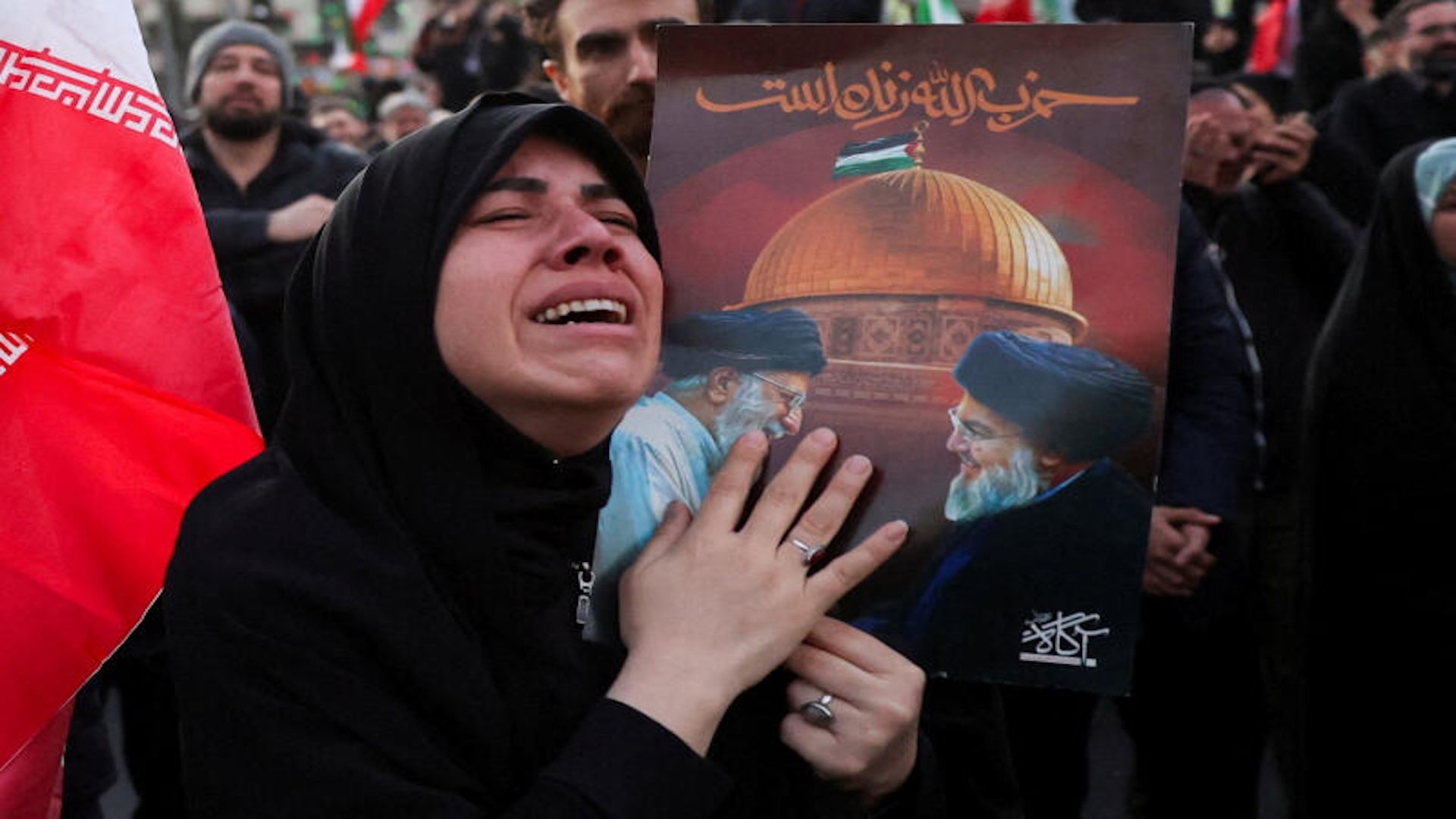 A woman weeps while clutching a portrait at a gathering in Enghelab Square, Tehran, following the death of Supreme Leader Ayatollah Ali Khamenei on March 1, 2026.