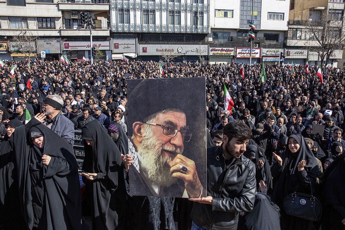 A man holding a portrait of the Supreme Leader as people mourned his killing at a rally in Tehran.