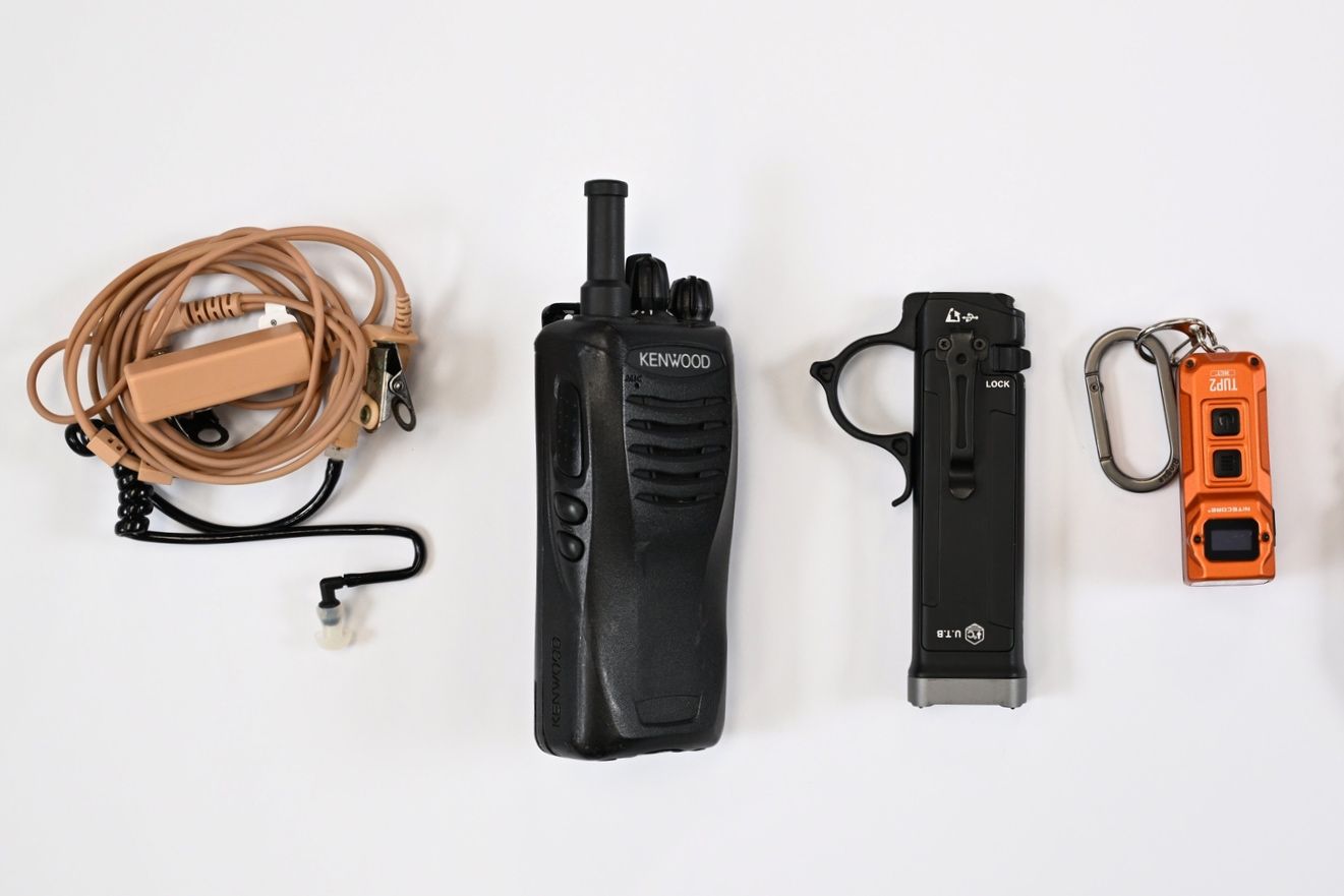 Tjen’s essentials during assignments: (from left) an earpiece and walkie-talkie for communicating with team members, and tactical flashlights.