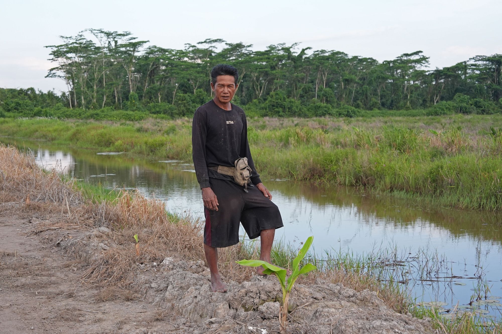 Farmer Rafii Abdul Sani stands by a river in Punai village, Kapuas regency.