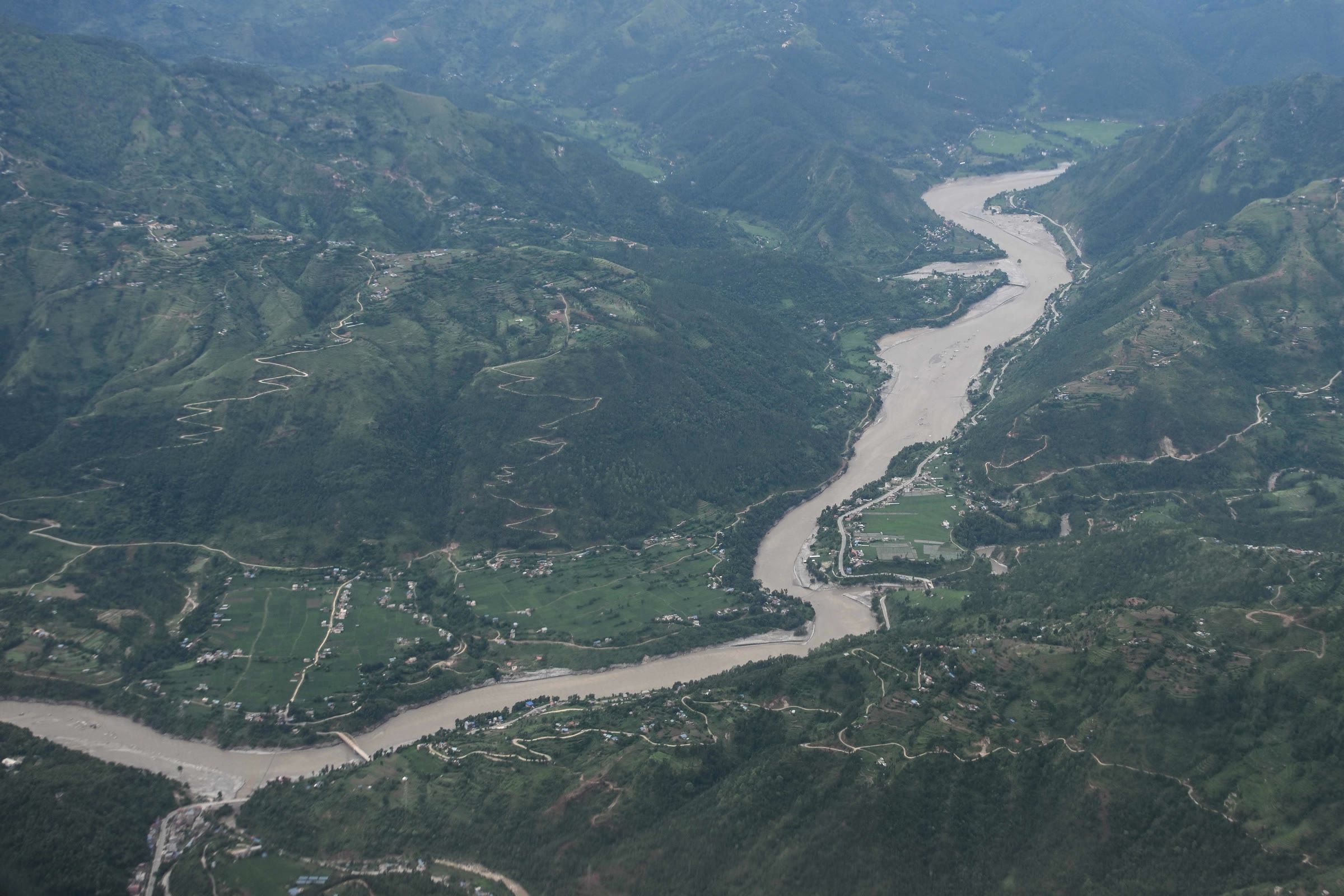 Aerial view of the swollen Trishuli River winding through green hills and settlements in Nepal’s Dhading district.