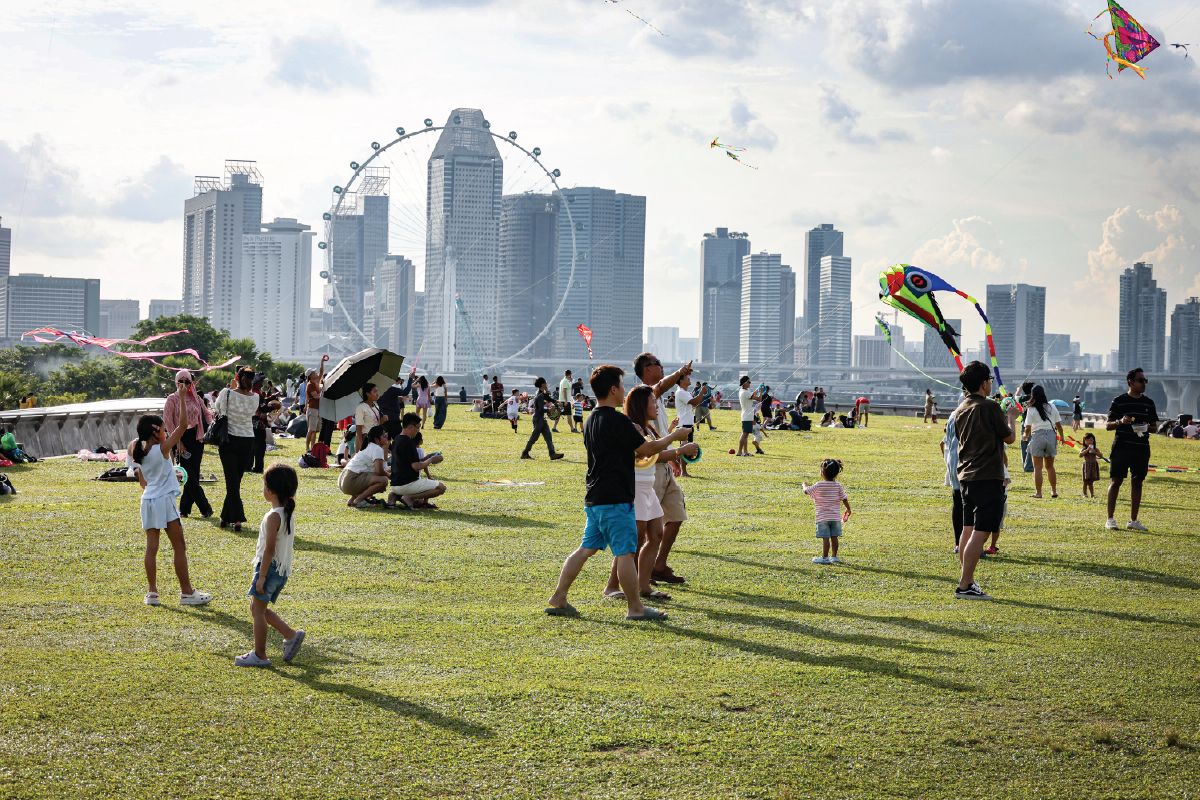 Families fly kites outdoors at Marina Barrage in June, before the haze.