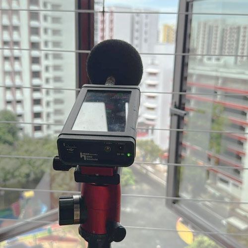 The sound meter on the tripod facing up from an open window