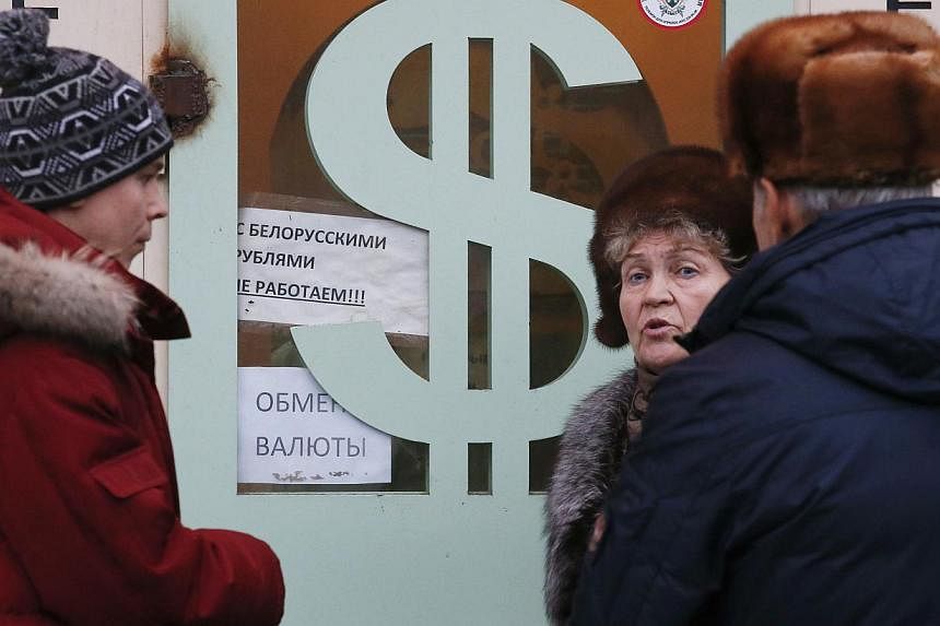 People gathering near a currency exchange office in Moscow on Dec 17, 2014. The US dollar rose on Thursday after the Federal Reserve signalled it was on track to raise interest rates next year. -- PHOTO: REUTERS