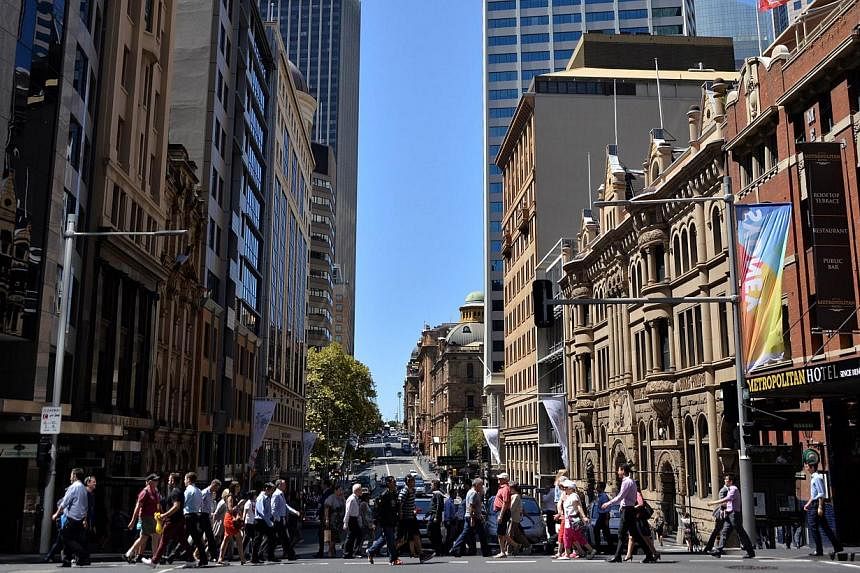Pedestrians crossing a road in the Sydney CBD on March 3, 2015. Australia's central bank cut its cash rate a quarter point to an all-time low of 2.0 per cent on Tuesday, aiming to spur a sluggish domestic economy while keeping downward pressure on th