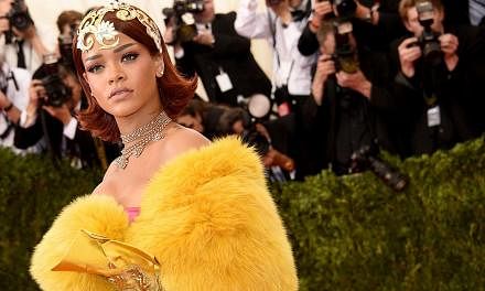 Rihanna wearing a gold tiara and flowing yellow robe at the New York Met Ball on May 4, 2015. The city's party of the year, attended by stars such as Madonna, George Clooney, Sarah Jessica Parker and Robert Pattinson, chose China as the theme of its 